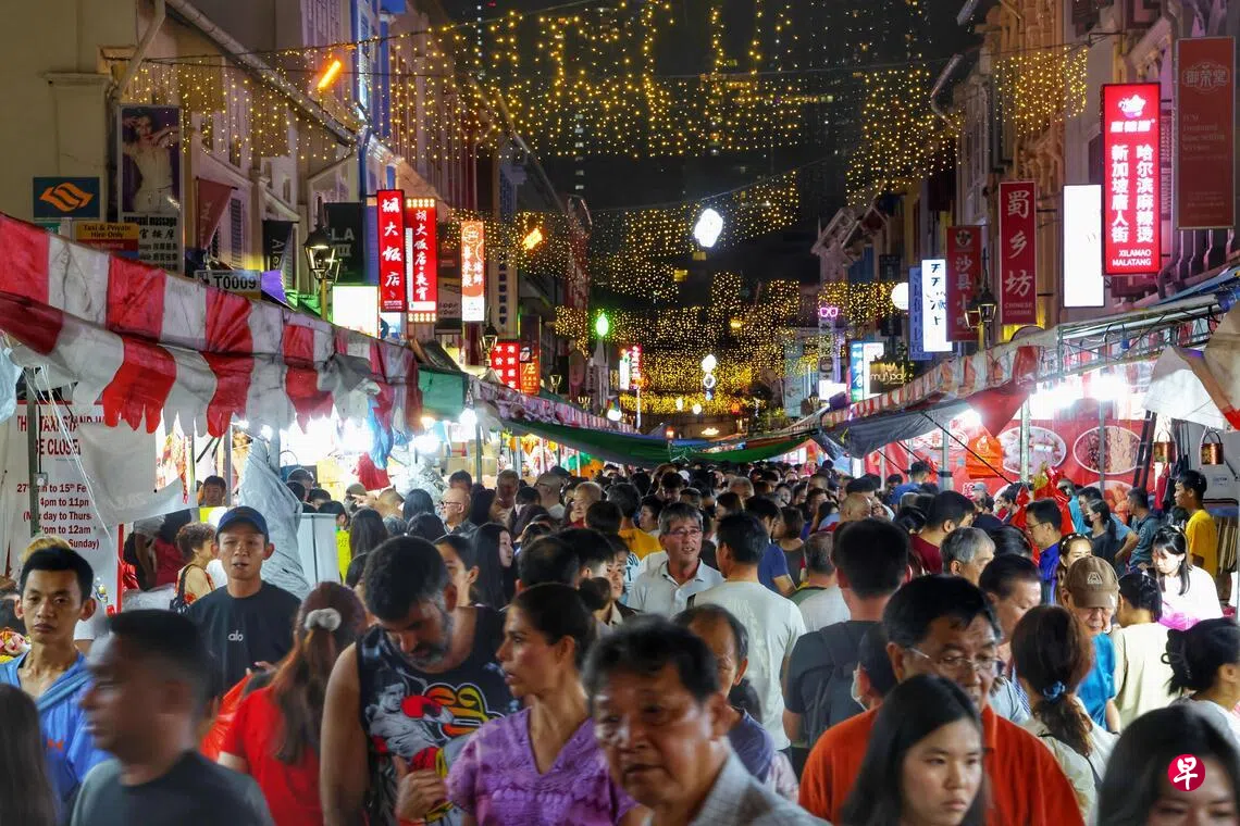 Image 15: 摊主用扬声器叫卖，推出诱人促销，希望在蛇年最后几小时，清掉剩余的货品。公众也在年夜饭之后，趁着雨后放晴，纷纷到场感染气氛，等待鞭炮燃放。 （郑一鸣摄）