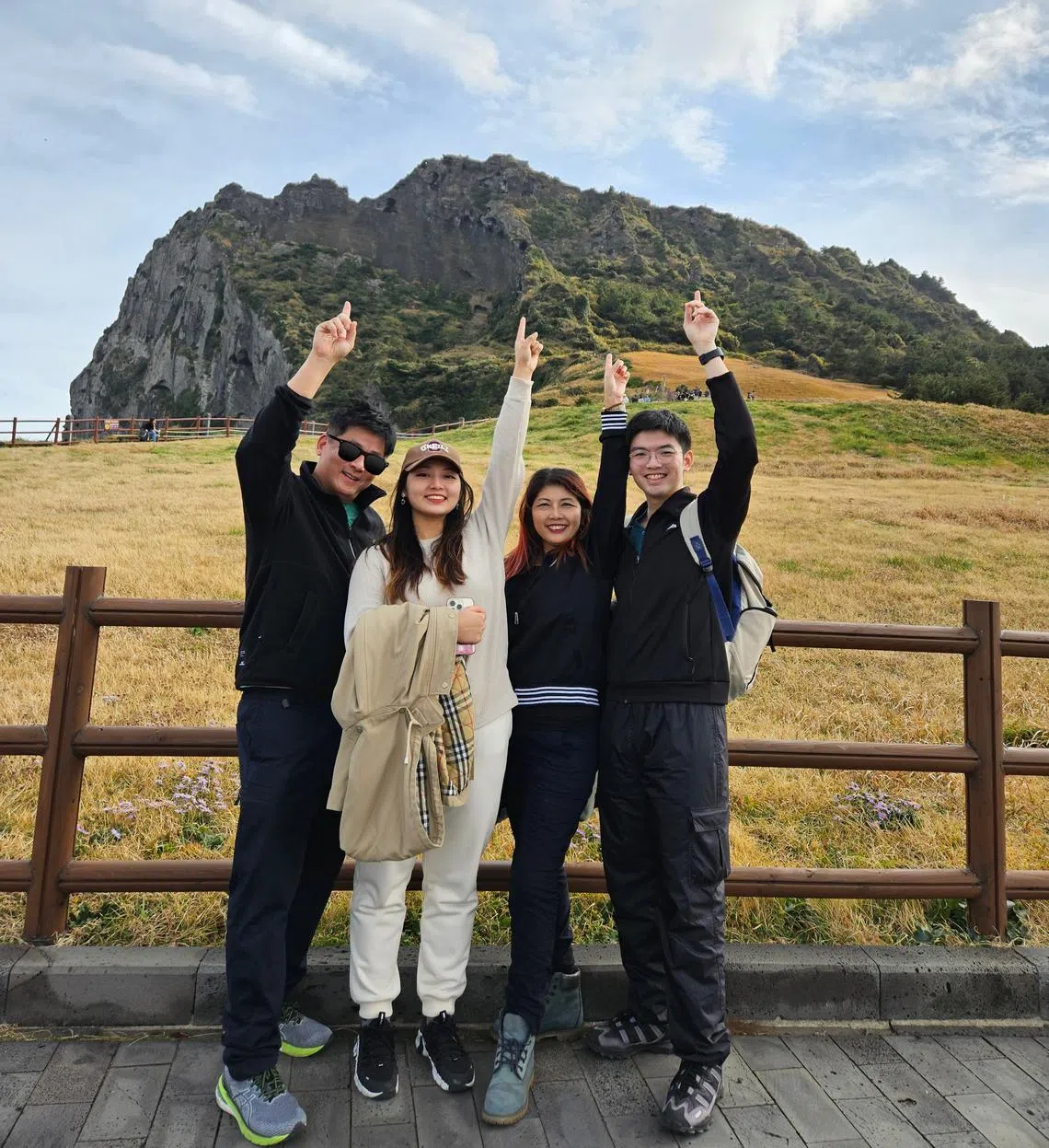 陈爱明（右二）和儿子（右一）与女儿（左二）感情融洽，孩子们长大后还会和她拥抱亲脸颊。（受访者提供）