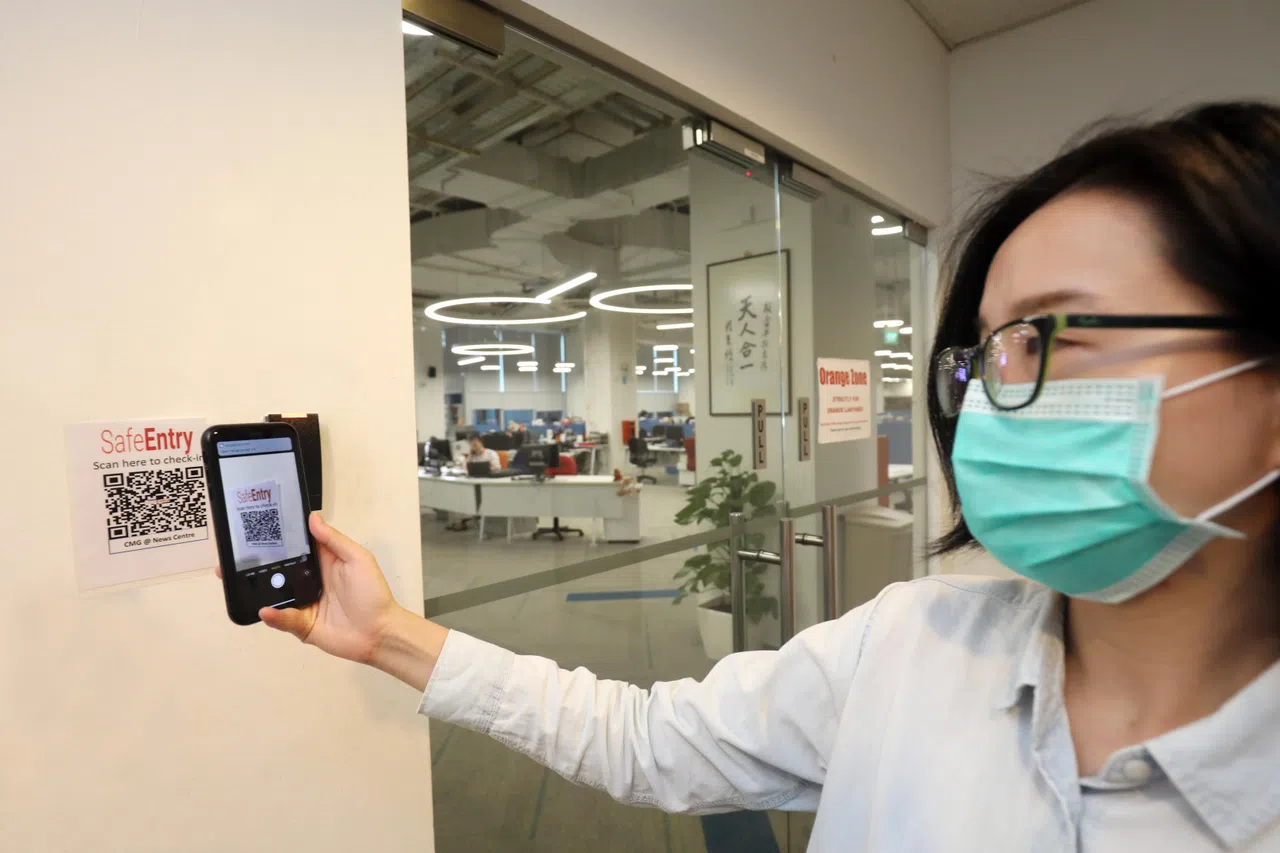 疫情期间，同事须在门口登录SafeEntry才进入办公室。（邝启聪摄）