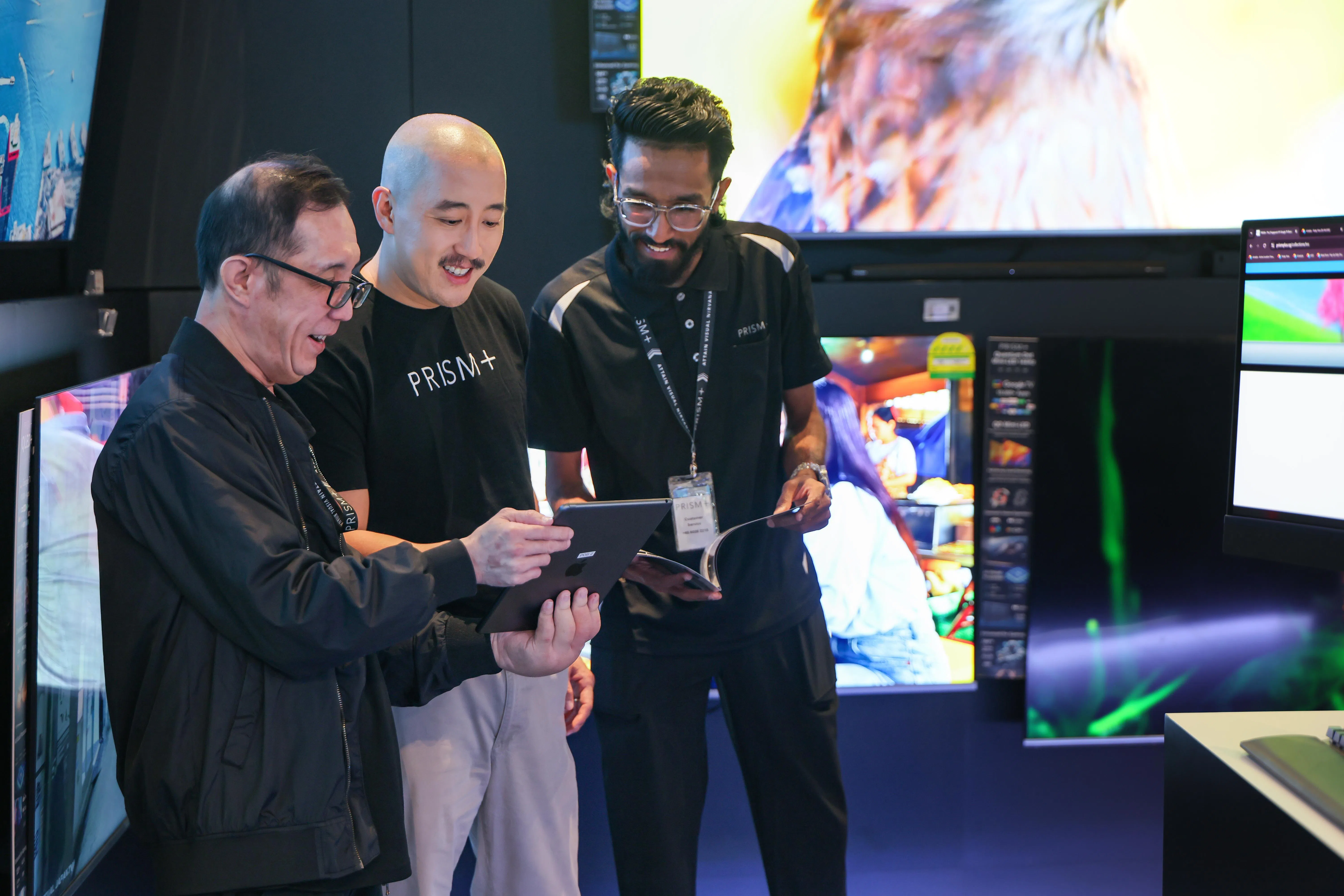 黄其伟（中）在新达城商场的Prism+首家产品体验店与员工交流。（龙国雄摄）