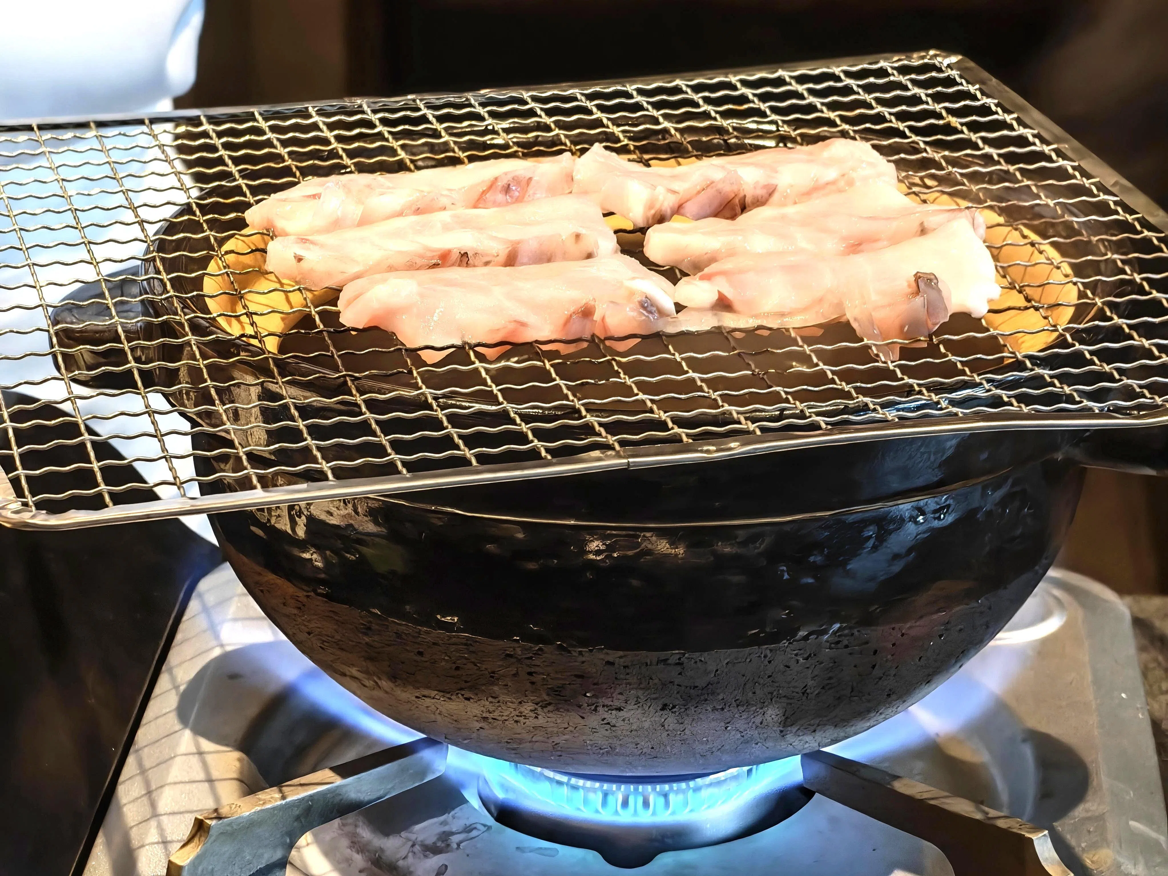鱼肉切片铺在铁架上，借蒸汽微微逼熟，更能突出其风味。（陈爱薇摄）