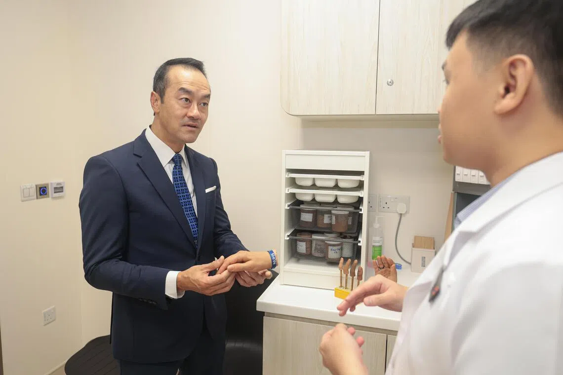 卫生部兼人力部高级政务部长许宝琨医生（左一）参观手与显微修复中心。（李冠卫摄）