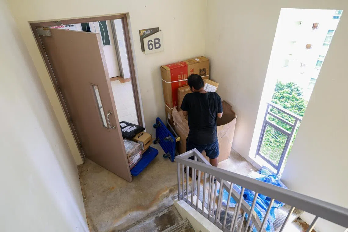 一些配送公司的人员，在鲜少有人使用或经过的停车场楼梯口卸货和分拣。（陈斌勤摄）