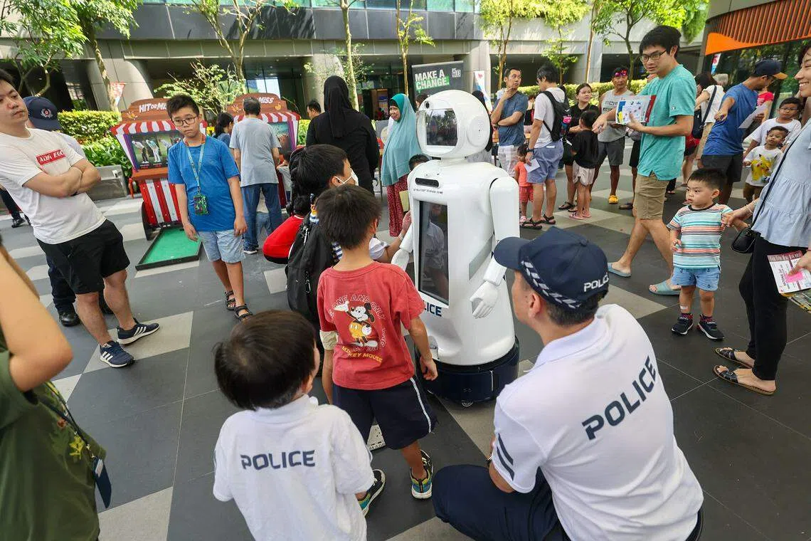 公众在警员引导下尝试与AI机器人CODY互动。（陈渊庄摄）