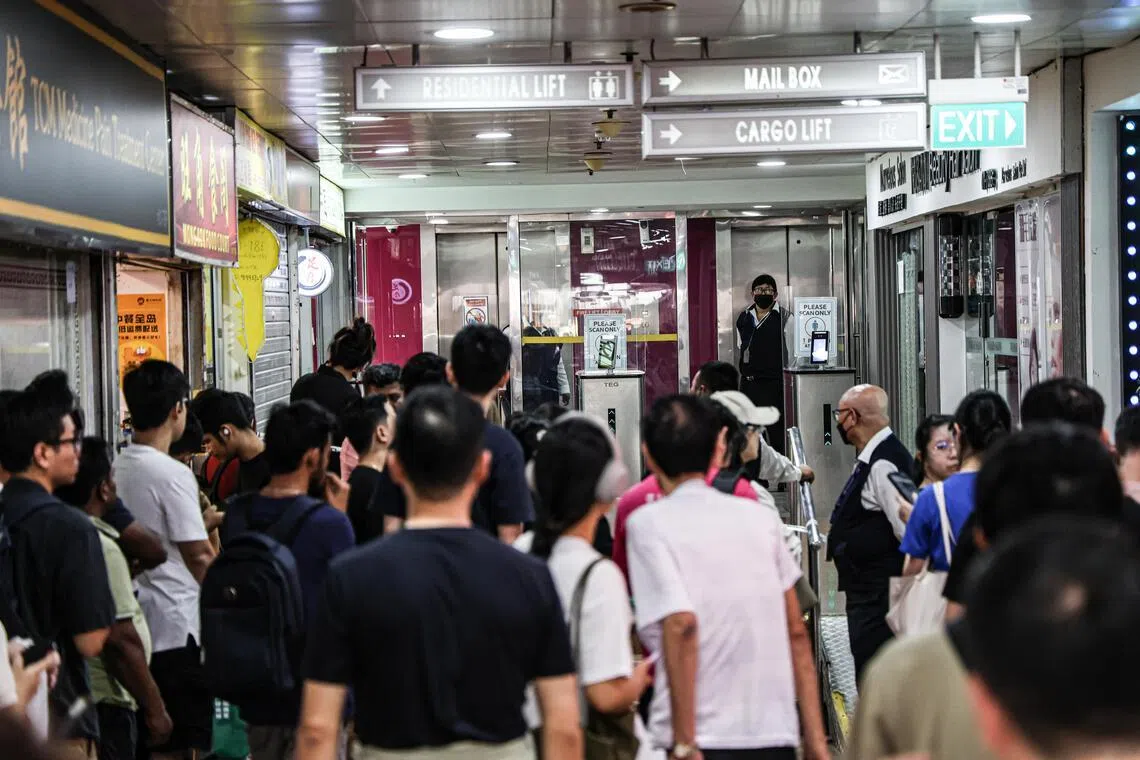 警方和民防部队共疏散了20名住户，一批居民在珍珠坊底层的商场等候住家解封。（关俊威摄）