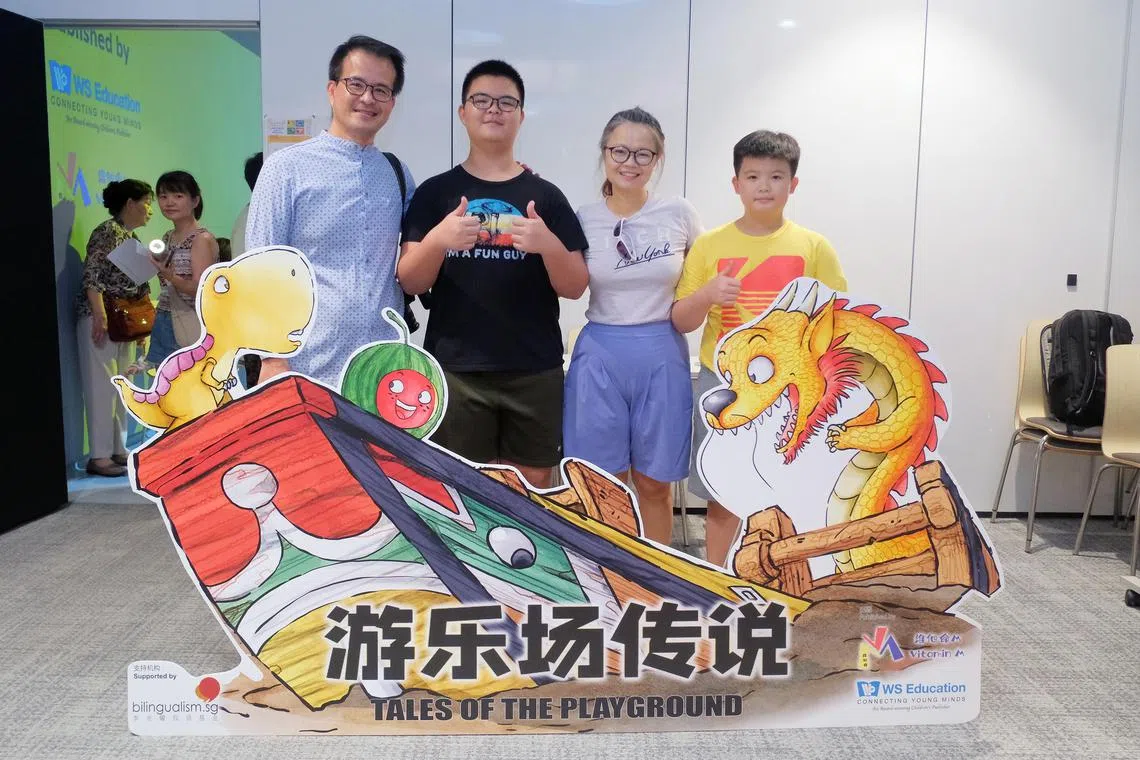 洪益兴（左一）与家人在绘本发布会合影。绘本以本地游乐场为背景，通过亲切熟悉的场景和拟人化角色，激发孩子对华文的兴趣。（受访者提供）