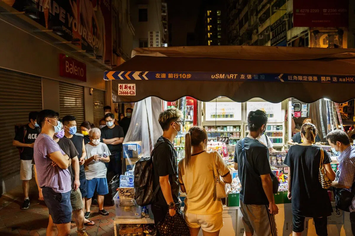 多个香港市民今天在一个报摊外排队，等候购买《苹果日报》。（彭博社）