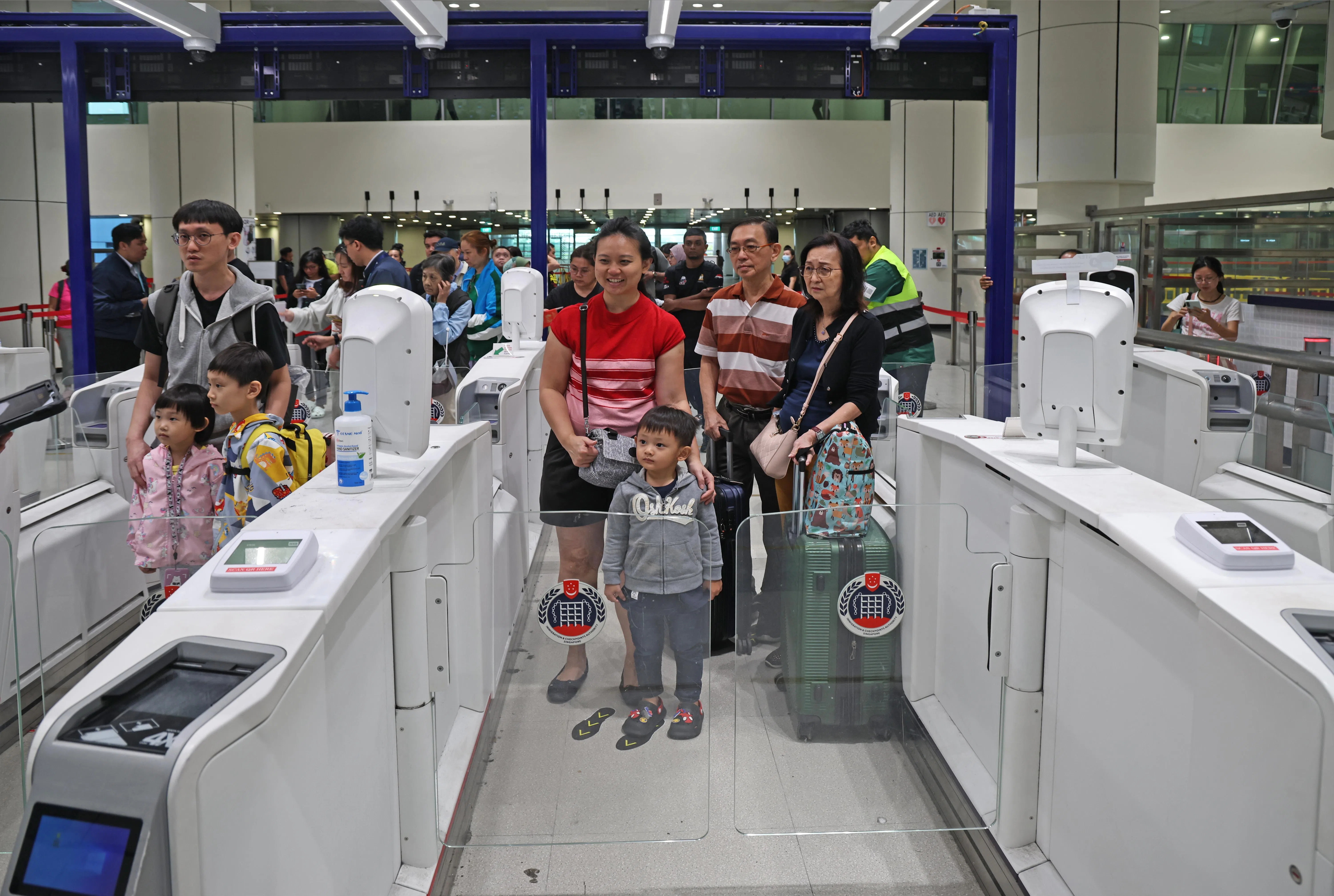 佘俊文（38岁）和妻子、三子女及家中两老，分别使用两条特别辅助通关通道出境。（陈渊庄摄）