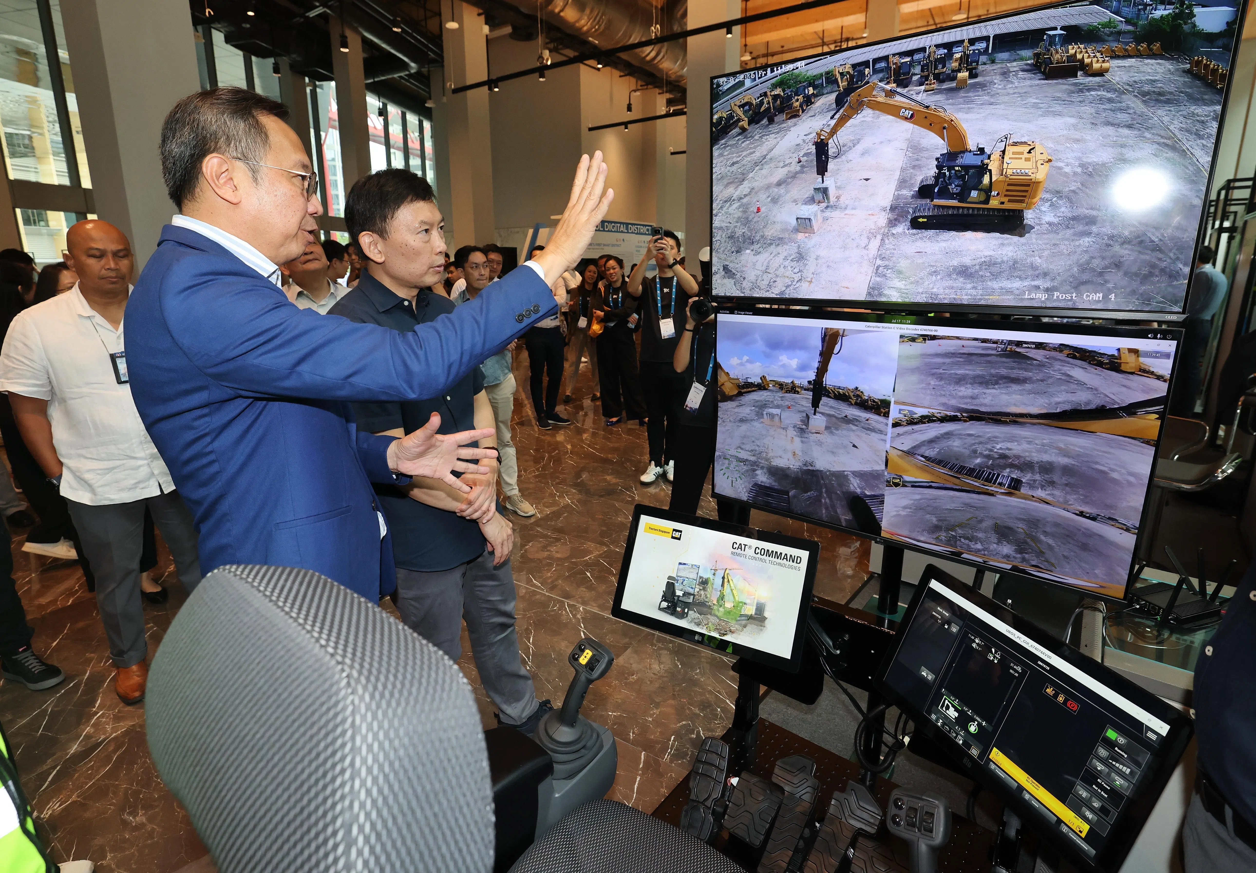 国家发展部长徐芳达出席建筑科技活动ConTech@PDD，图为他了解了挖土机远程控制系统。这个系统金额让一名操作员坐在控制台前，远程操控多达五台挖土机。（唐家鸿摄）