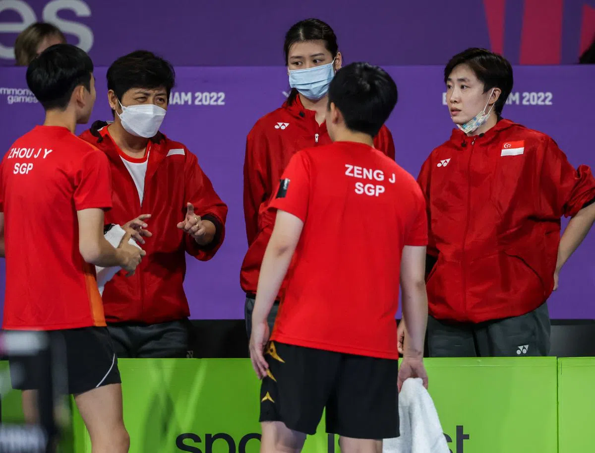 女队总教练井浚泓（左二）在比赛中给参赛队友指导。（叶振忠摄）