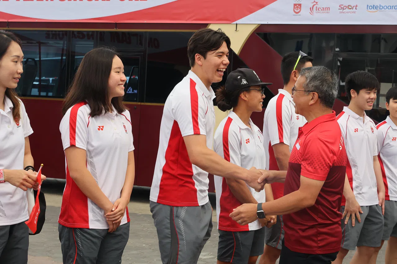 唐振辉部长（红衣）和墨士廉握手问好。（唐家鸿摄）