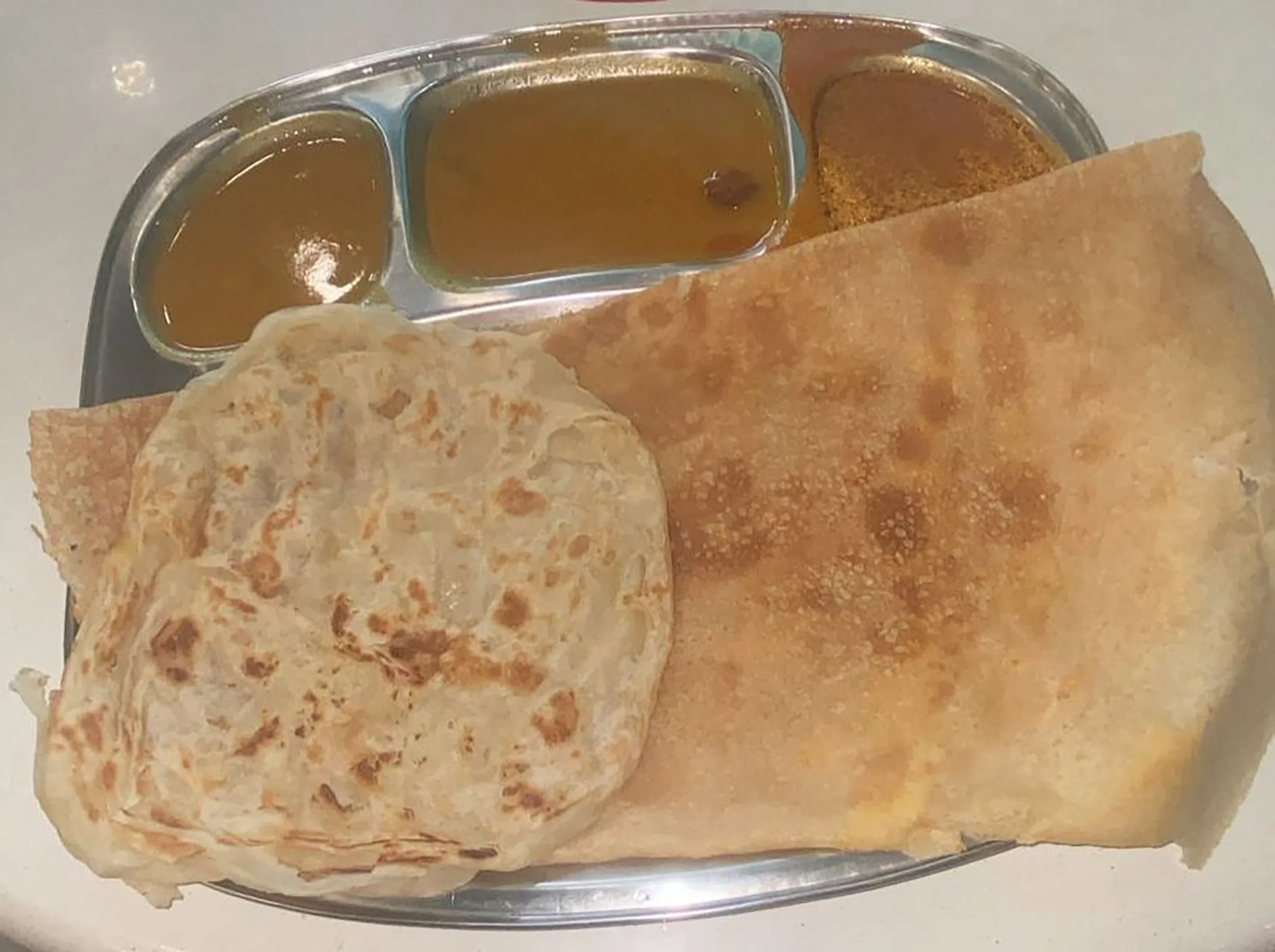 一份$3.50的印度薄饼（thosai）套餐也配有咖喱和一块印度煎饼。（图/金山岭提供）