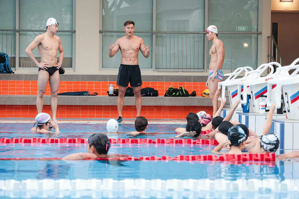 我国泳手张正伟（中）星期四在华中国际学校泳池指导AquaTech游泳俱乐部学员。（李冠卫摄）