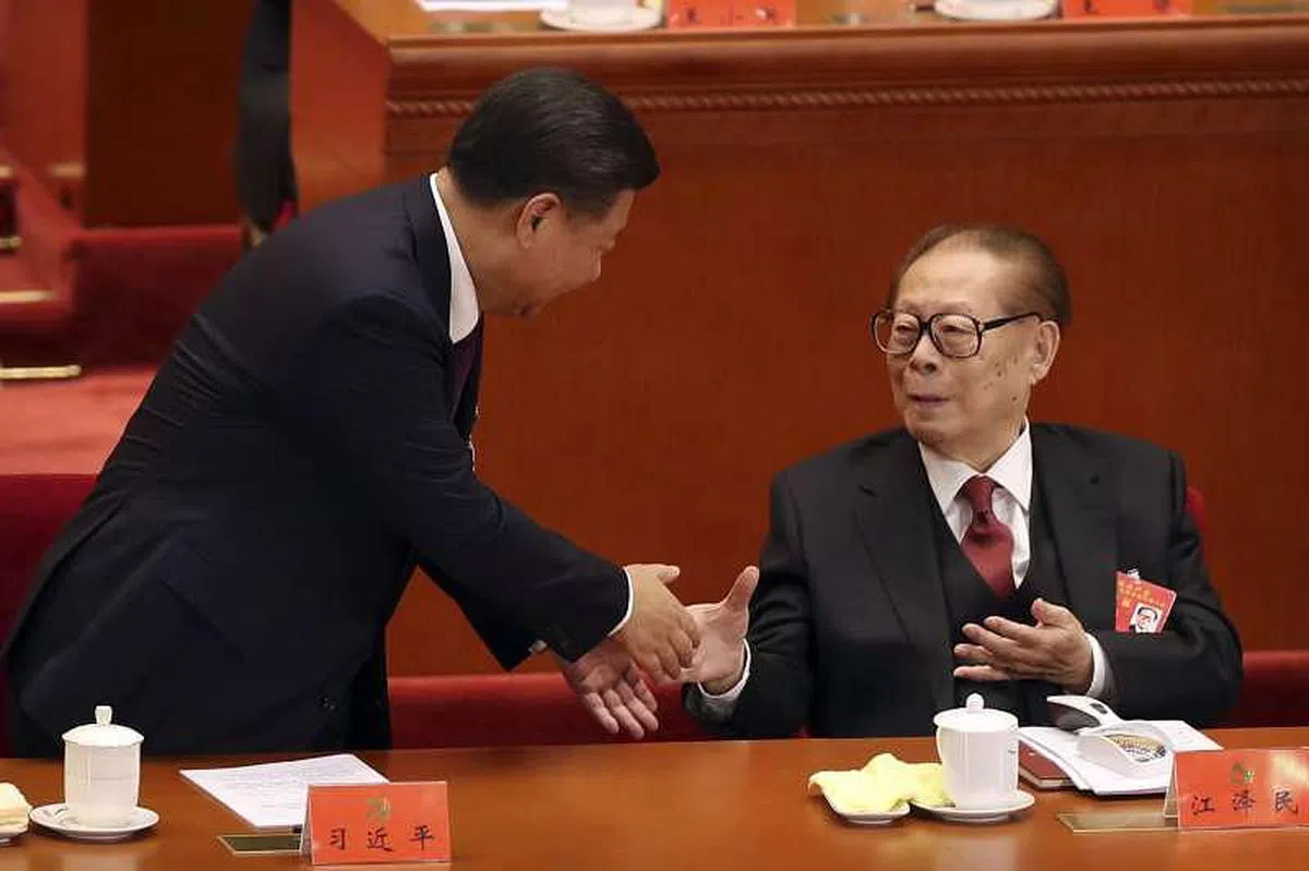 在2017年10月举行的中共十九大上，江泽民（右）以元老身份再度现身。图为江泽民在十九大会议上与习近平握手。（互联网）