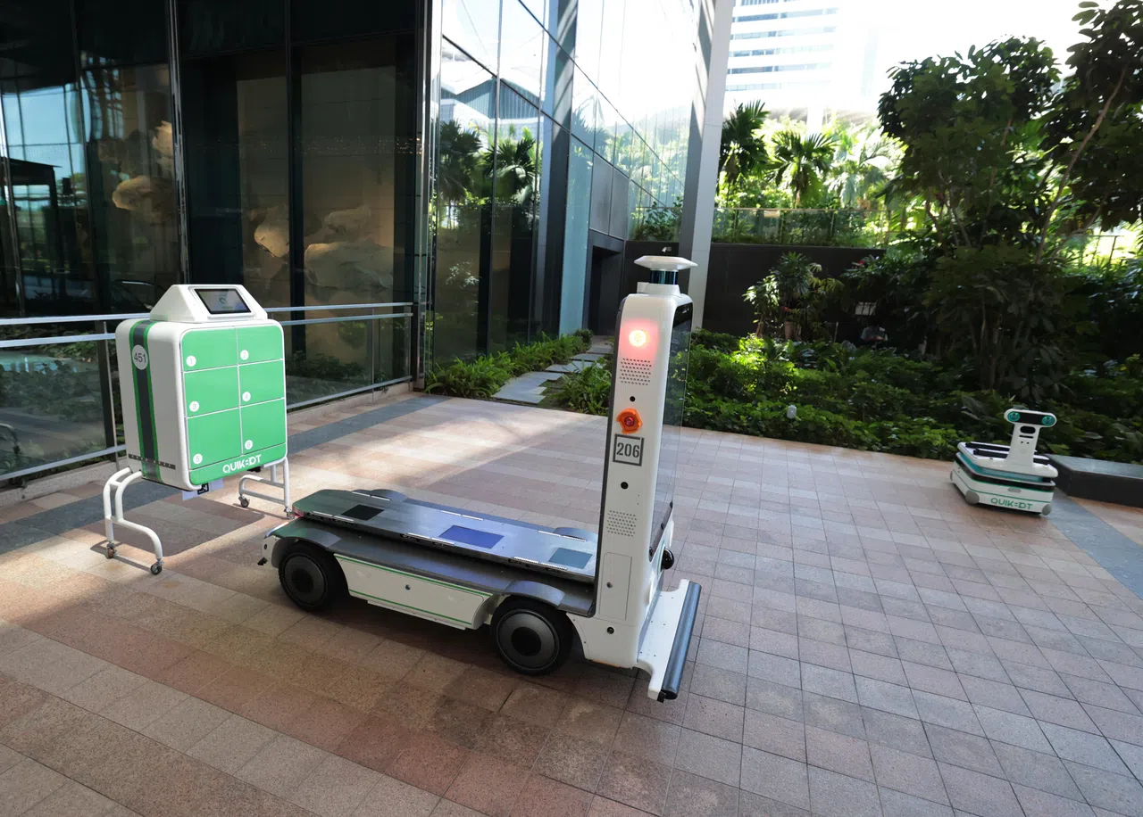 小机器人在指定地点把智能柜交给一台大型机器人。（梁麒麟摄）