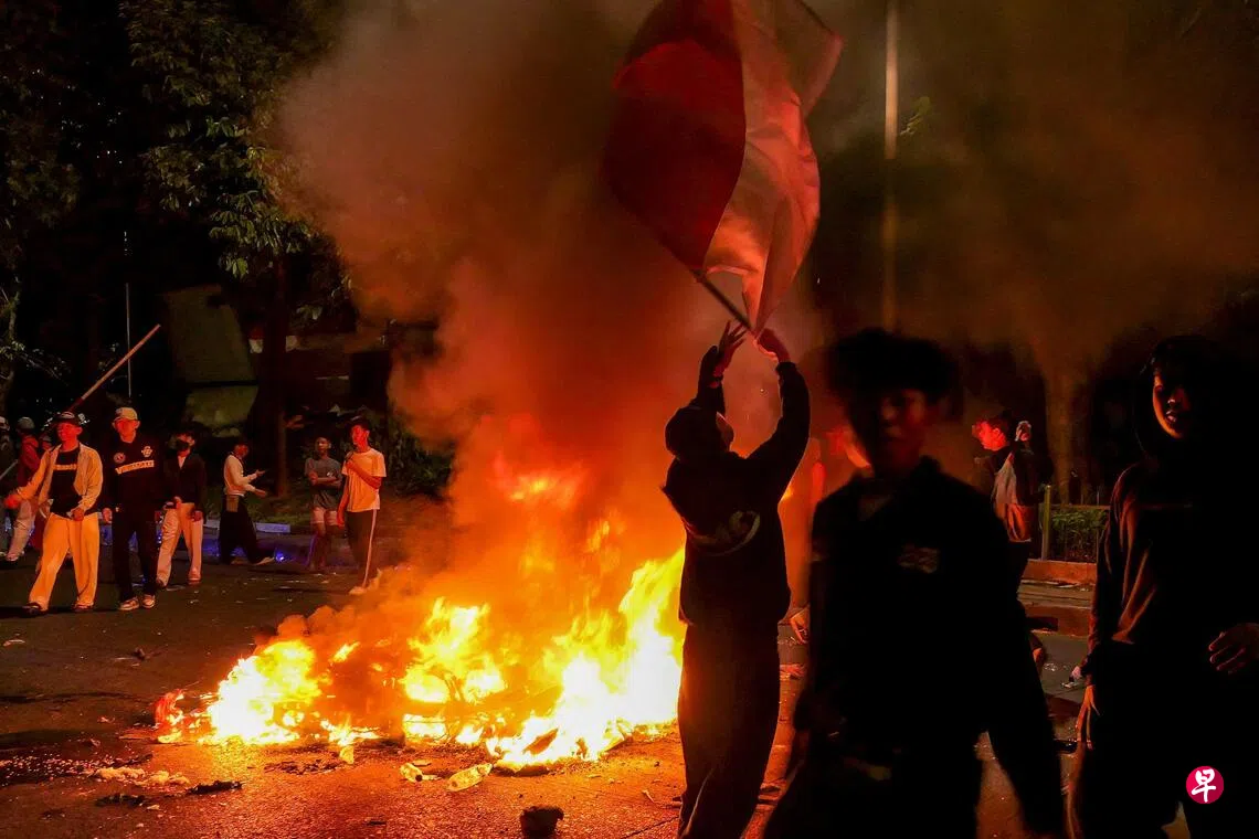 印尼民众周五的反腐集会在入夜后演变成骚乱，有人纵火烧毁警方电单车和警岗。 （法新社）