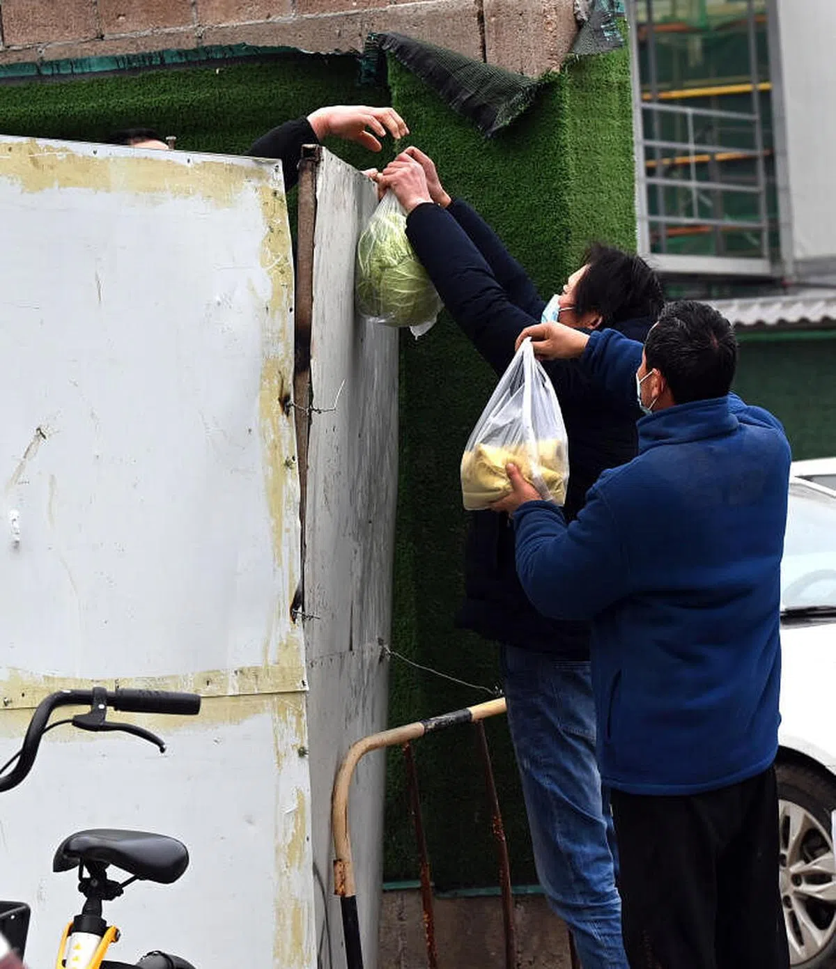 西安市团结南路一小区人员为封闭管理中的市民送上生活物资。（新华社） 