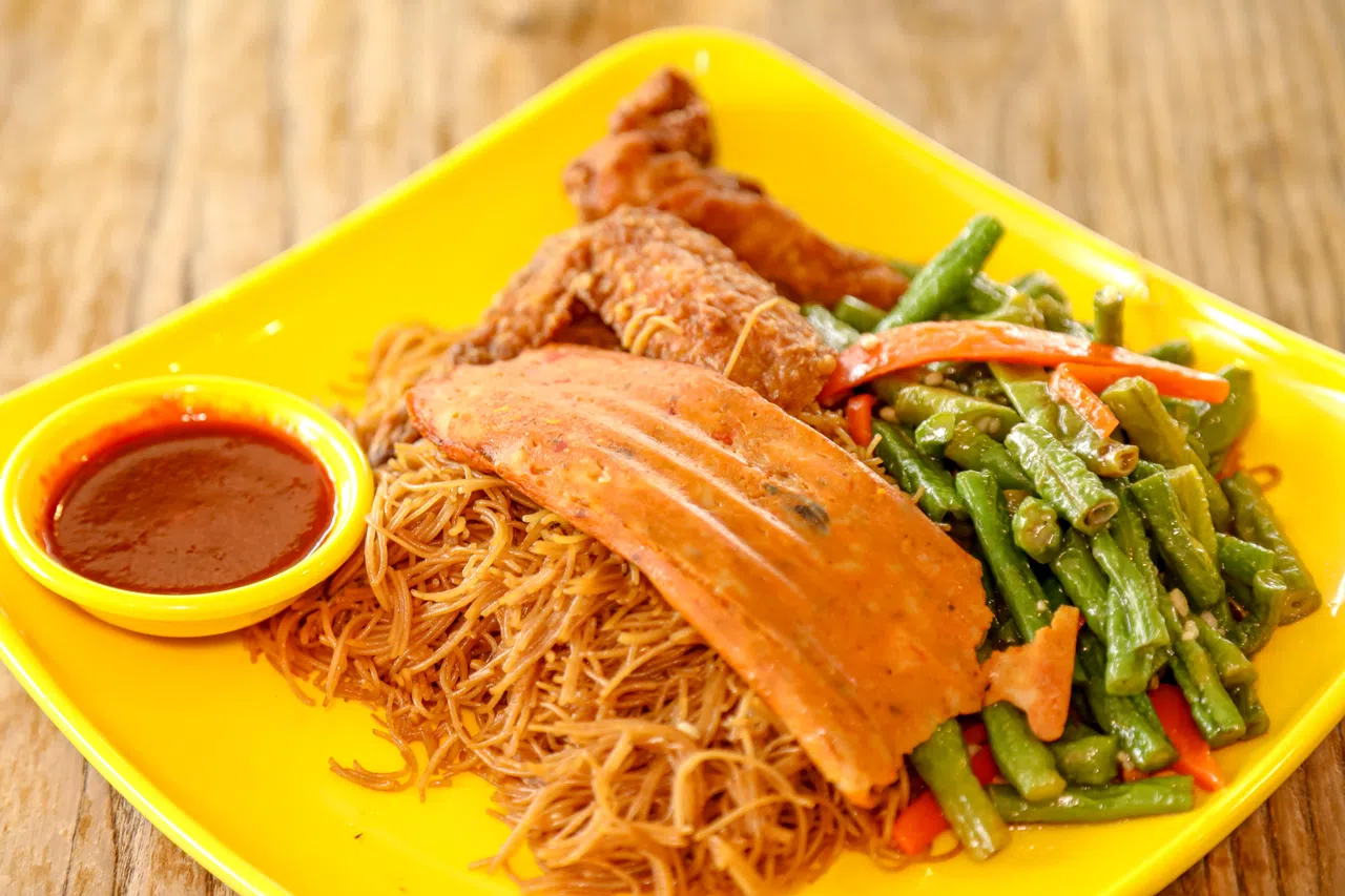 焱招牌炒米粉搭的配料有炸鸡翅、乌打和长豆，朴实美味。（刘欣怡摄）