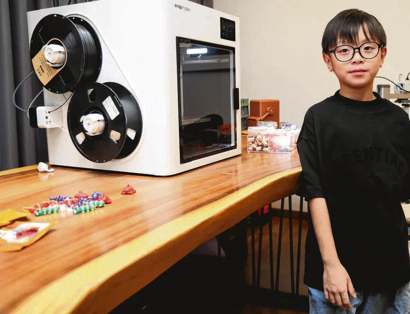李锐奇使用3D打印机打印玩具。