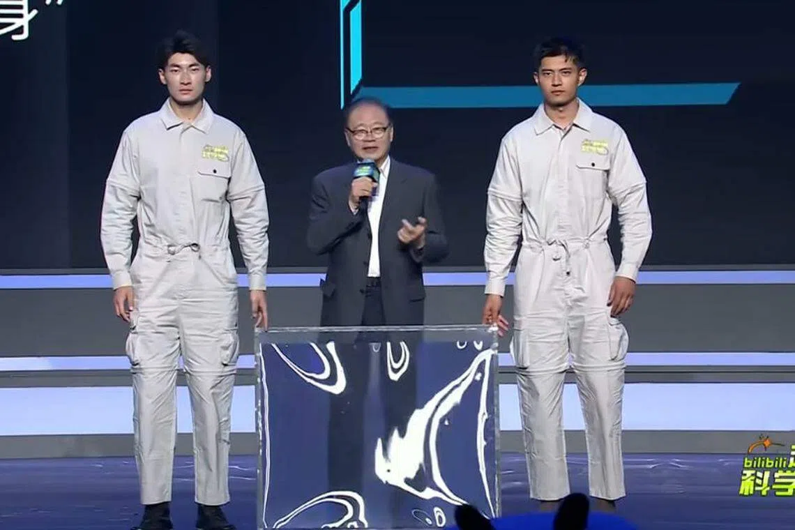褚君浩（中）还没展示“隐身术”前，两名工作人员手持一块面板站在他身旁。（哔哩哔哩视频）