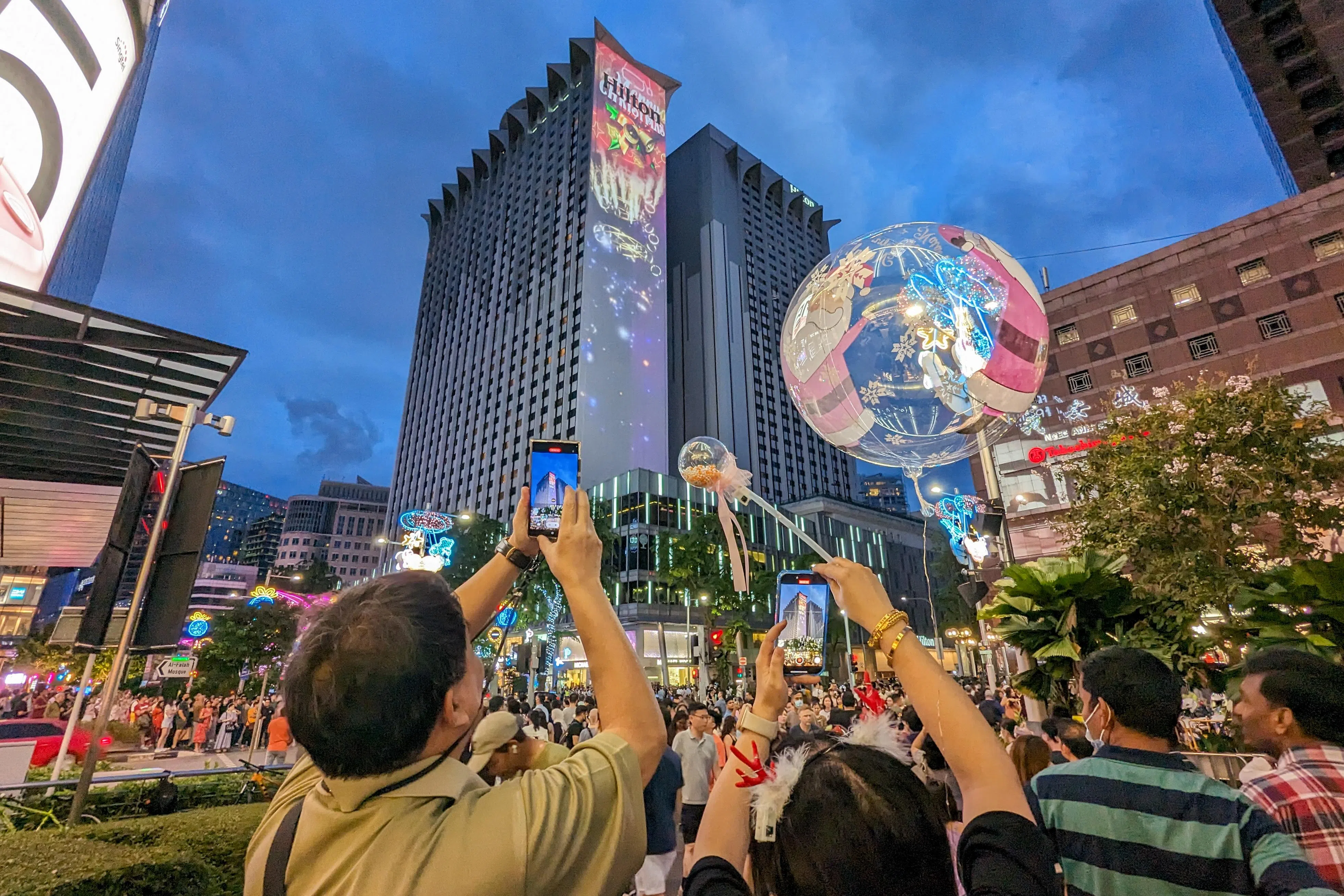 12月24日傍晚，乌节路首场圣诞街头还没开始，现场已经来了很多人，义安城外就人头攒动。（卓祾祎摄）