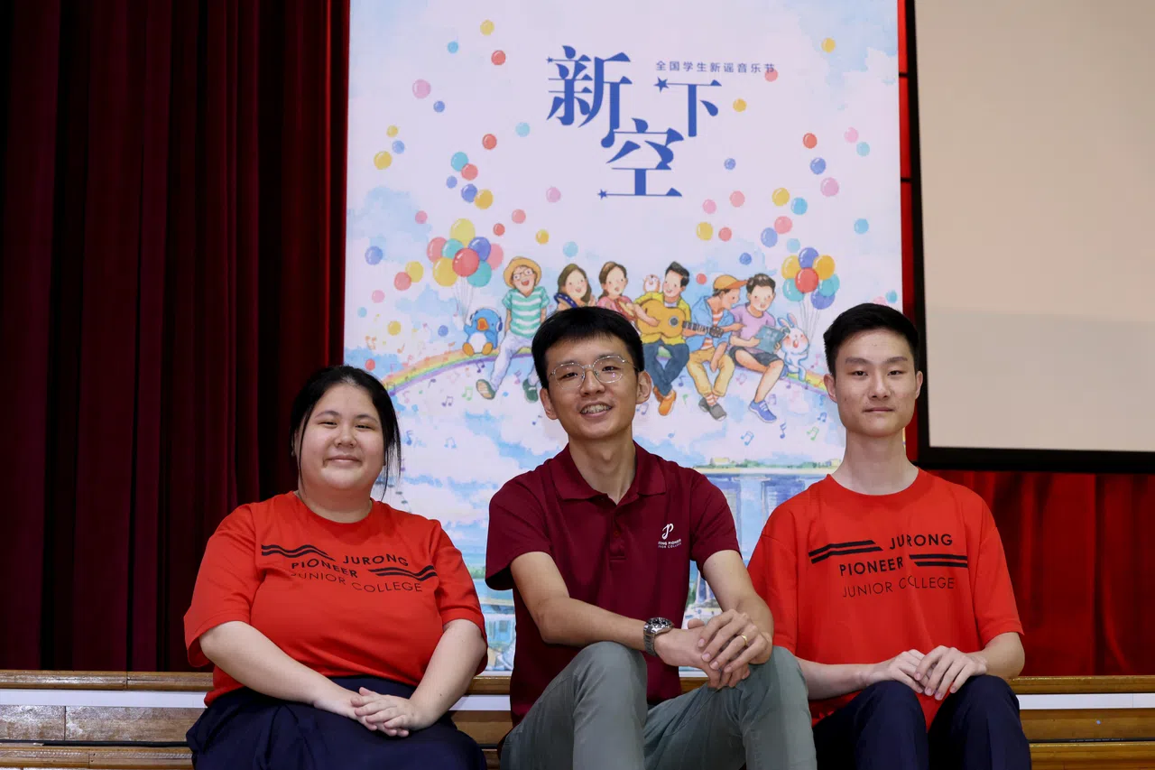 裕廊先驱初院学生郑映彤（右）说，参与分享会让他有更多勇气去尝试创作。华文老师吴桂豪（中）认为，为学生提供展示才艺的平台非常重要。学生王芋铃（左）初次参与分享会，对新谣改观了。（龙国雄摄）