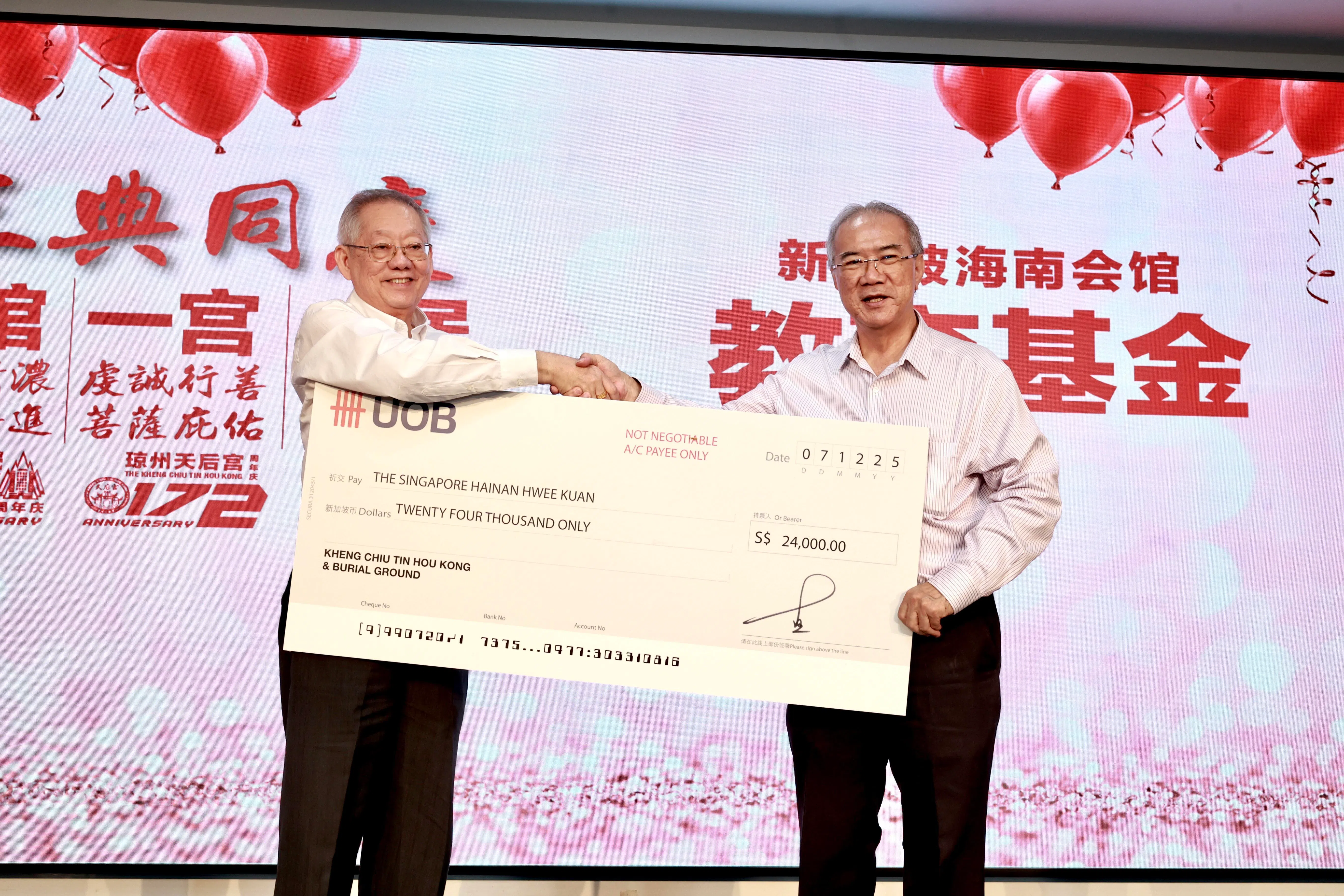 琼州天后宮主席王振胡（左）将2万4000元支票交给海南会馆会长潘家海，用于新设立的海南会馆教育基金。（周国威摄）