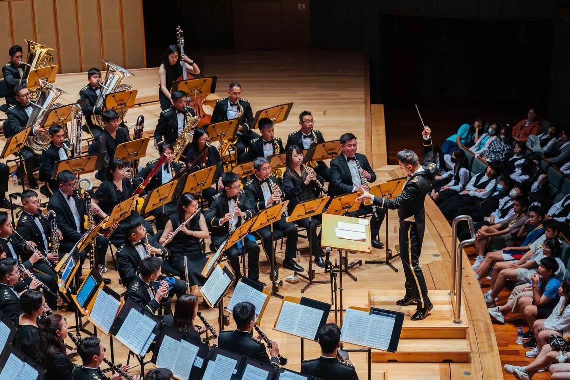 对于新加坡武装部队中央乐团音乐总监王轲斌（图中指挥）来说，学校乐团给了他一个舞台，教会他如何坚持并与人合作，也让他体会到音乐如何打动人心。（受访者提供）