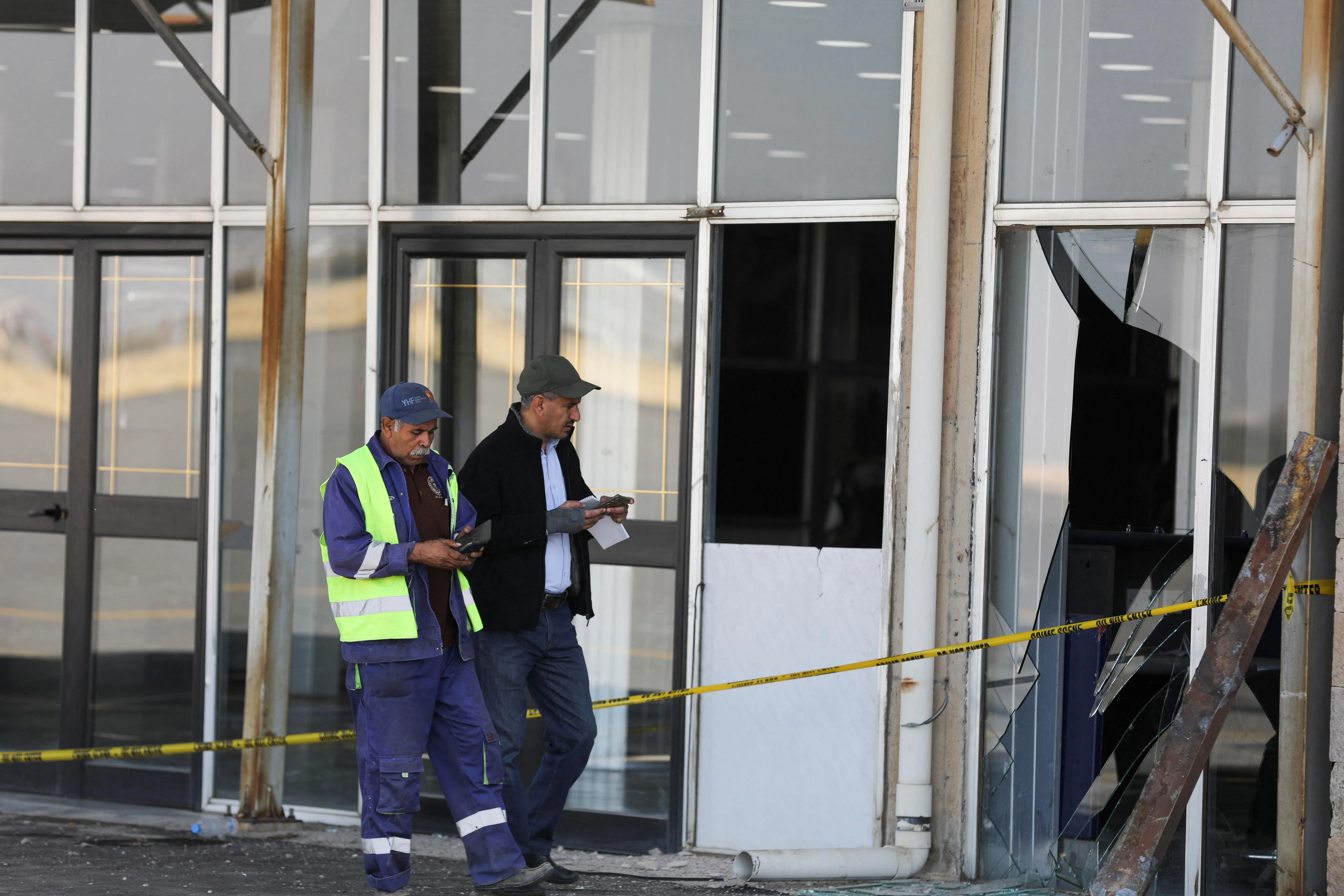 萨那机场员工星期五（12月27日）视察机场一栋建筑物的受损情况。（路透社）