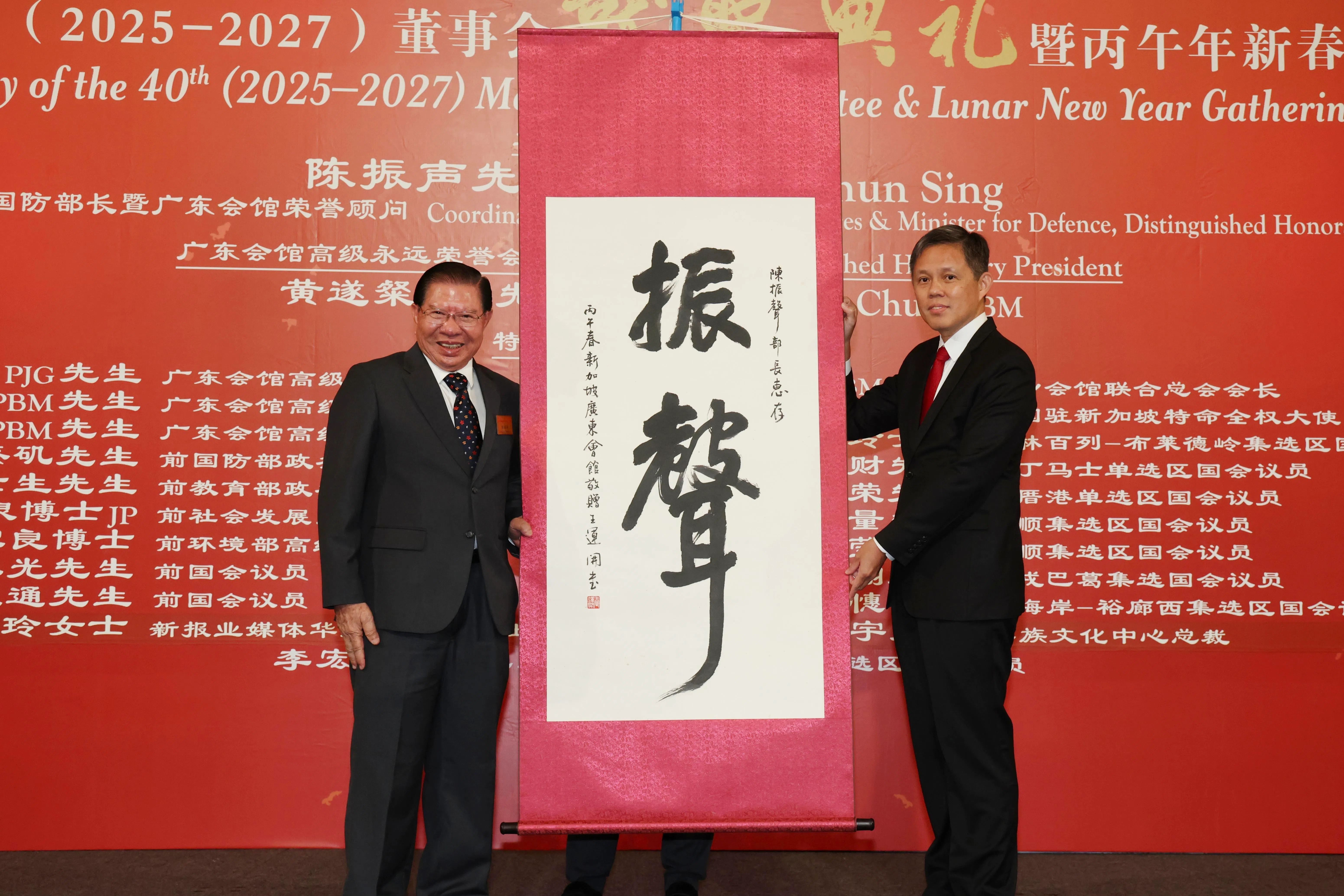 广东会馆高级永远荣誉会长黄遂粲（左）赠送陈振声书法作品留念。（郑一鸣摄）