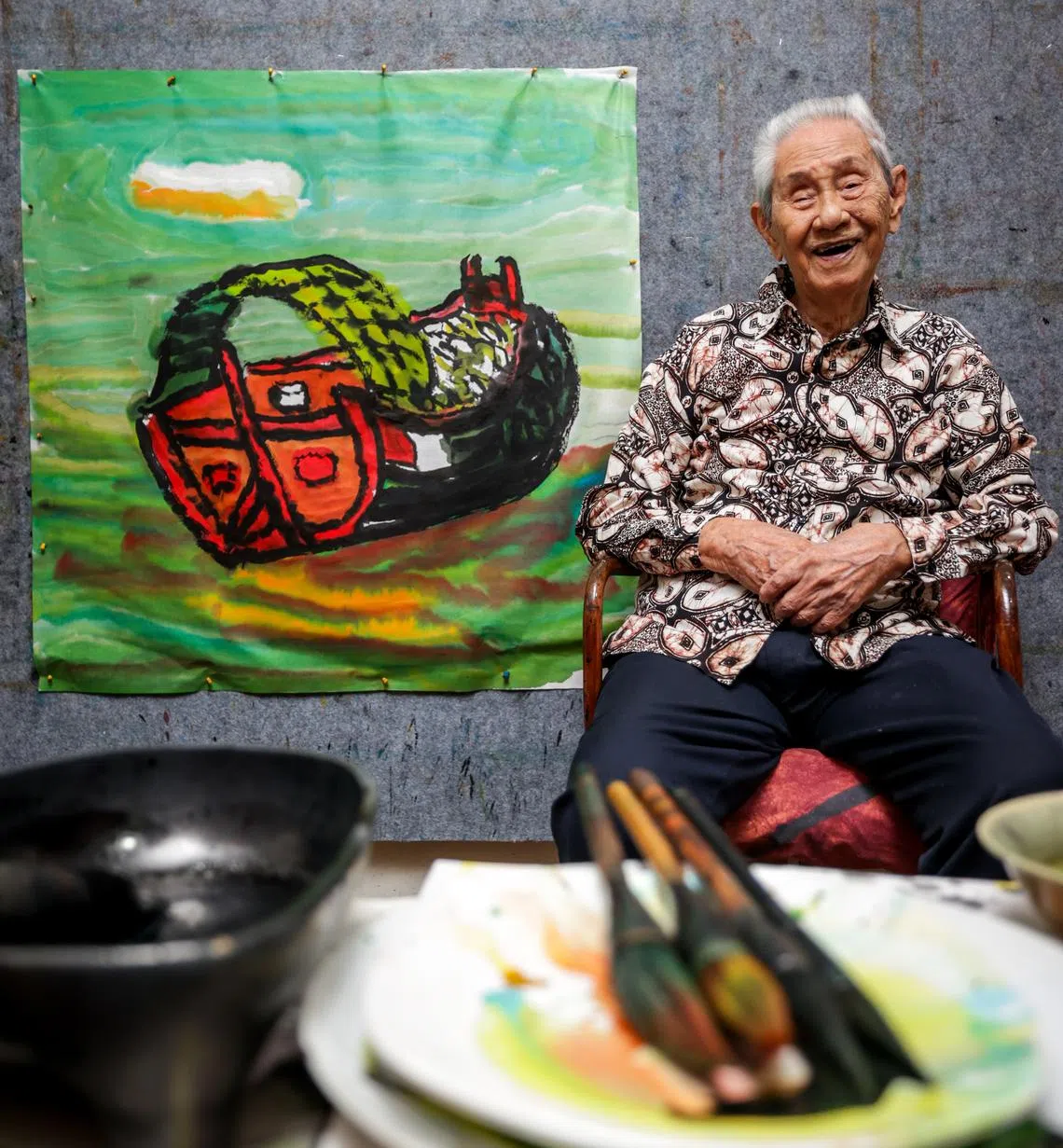 林子平应摄制组要求作画，完成驳船画后坐在藤椅上休息。（叶振忠摄）