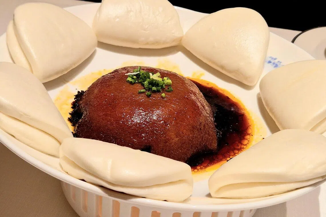 面子肉夹馍入口后，五花肉的脂香和梅菜的清香在口中散开。（陈爱薇摄）