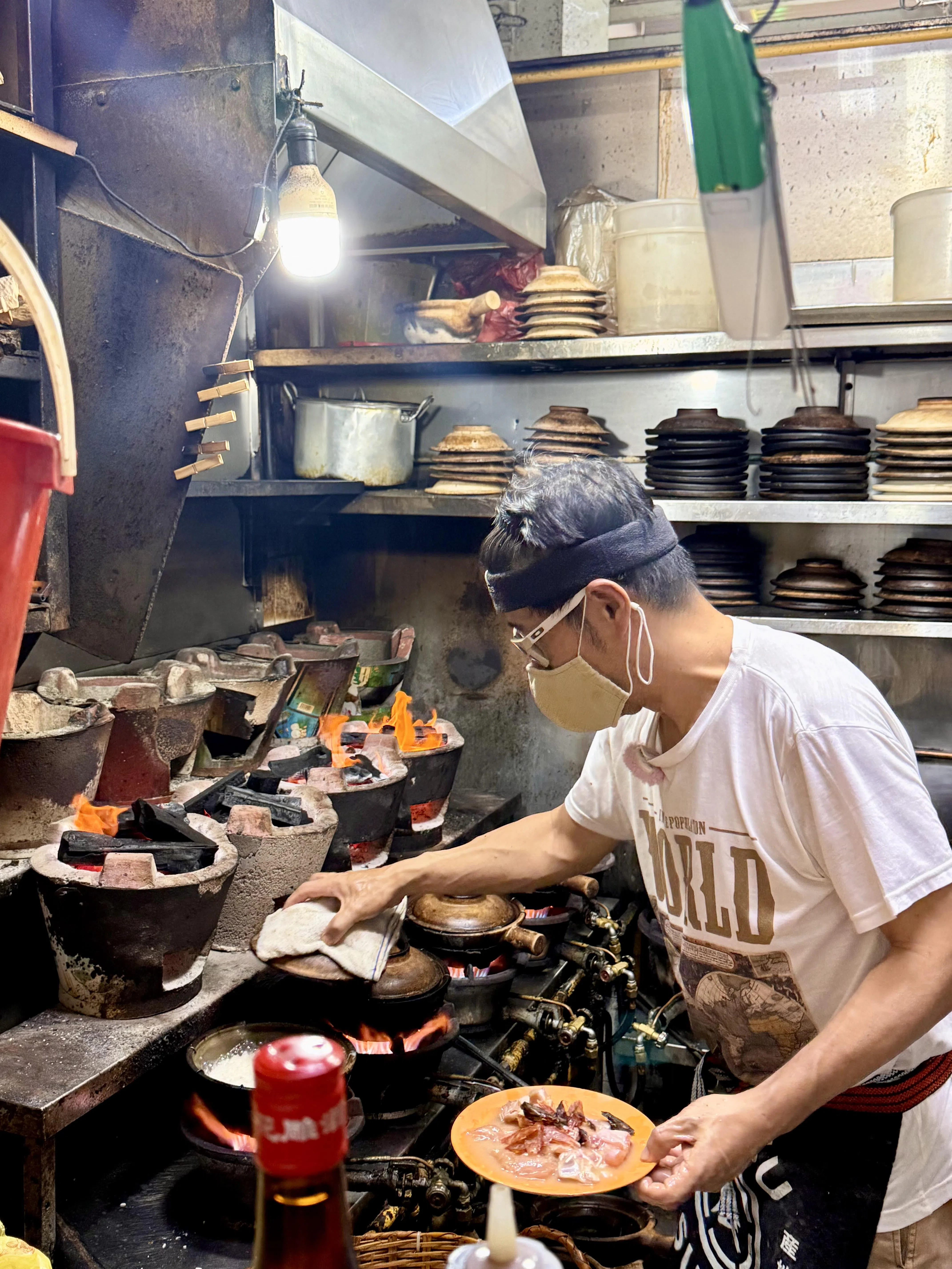 源源砂煲饭第二代摊主谢汉忠接手父亲生意，延续以火炭烹制砂煲饭的传统。（叶晓虹摄）