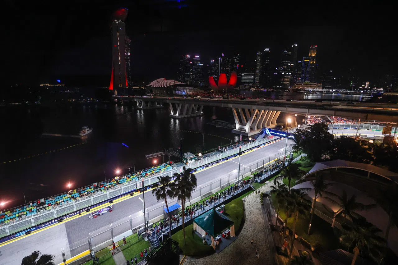 红牛二队赛车沿着滨海湾水域行驶，展现新加坡夜间赛之美。（白艳琳摄）