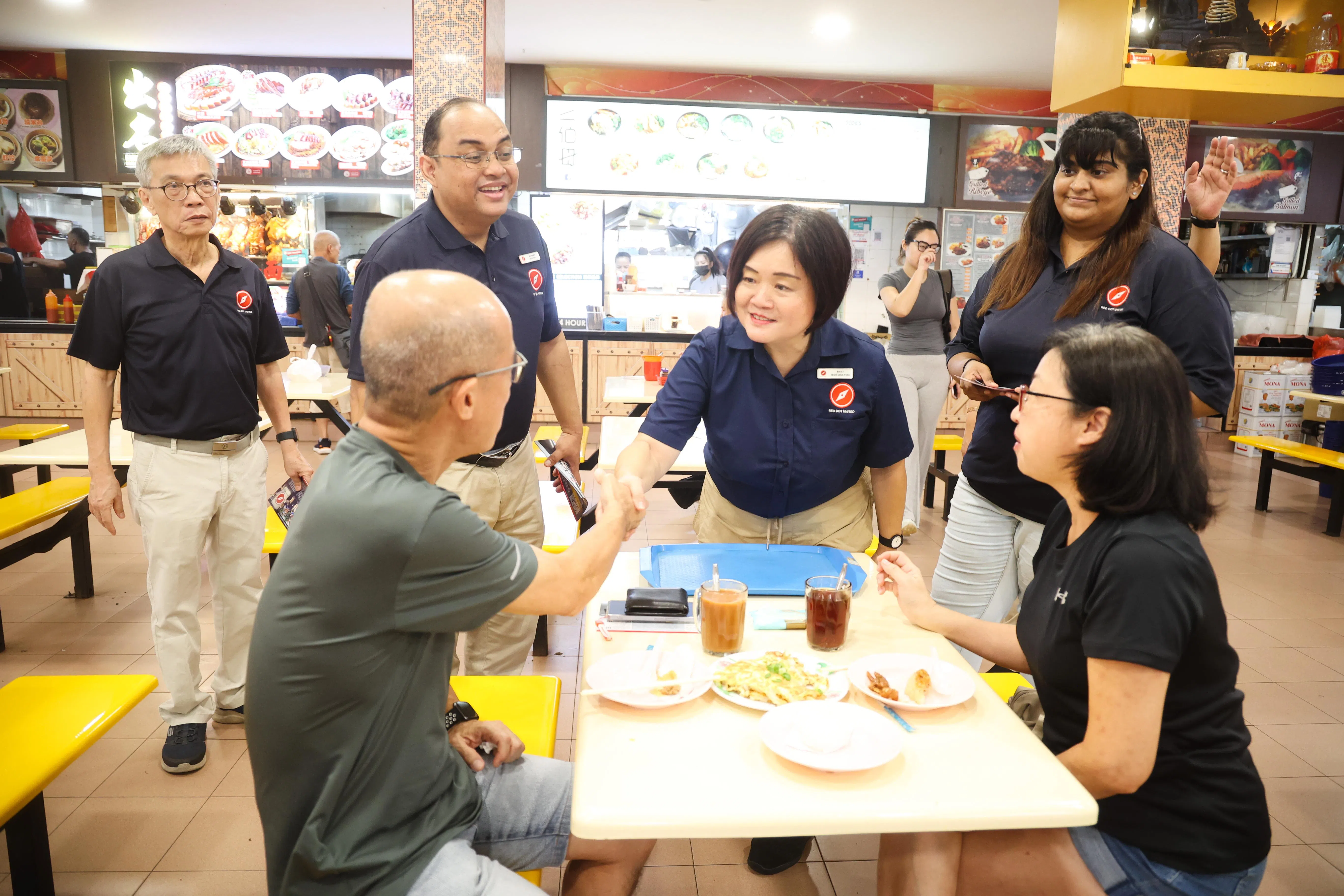 有意在裕廊中区参选的红点同心党，星期天上午9时许则到裕廊东31街的裕华商场一带，向居民介绍该党在裕廊中区的基层事务代表——59岁的教育工作者胡佳颖（中）。（蔡家增摄）