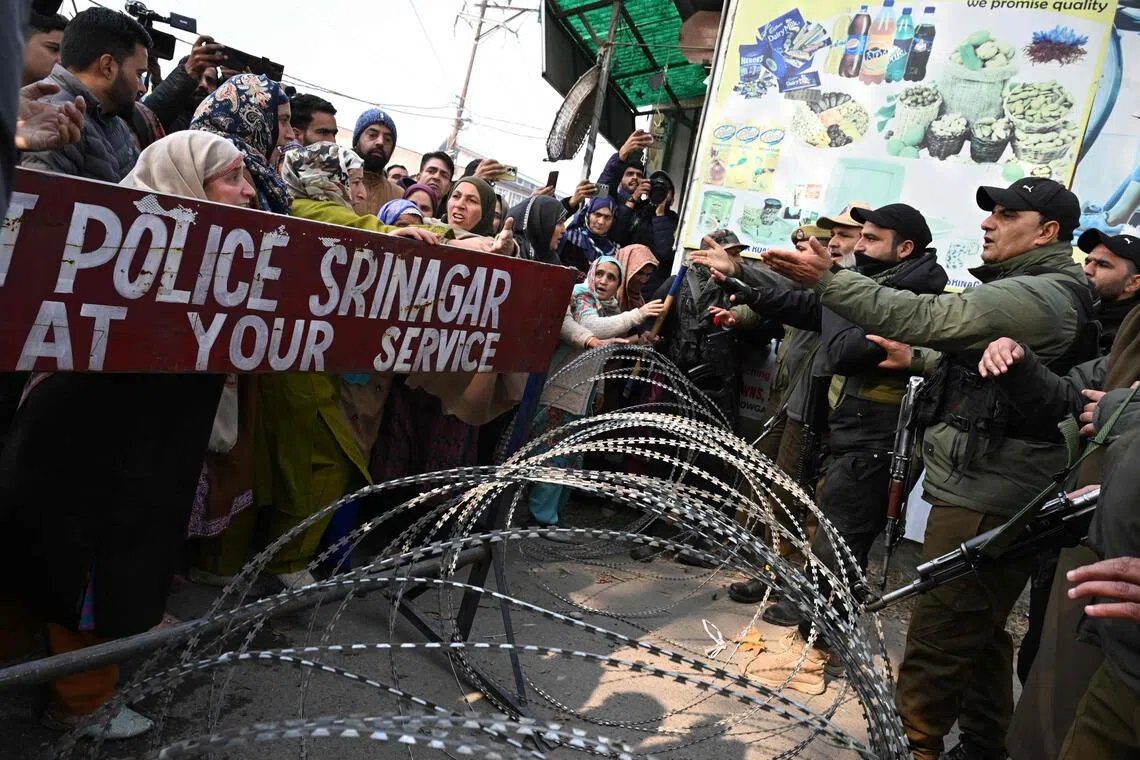 位于印控克什米尔地区的瑙钢区警局爆炸后，警方用铁丝网把警局围。被挡在外围的家属激动地求要当局交还遗体。（法新社）