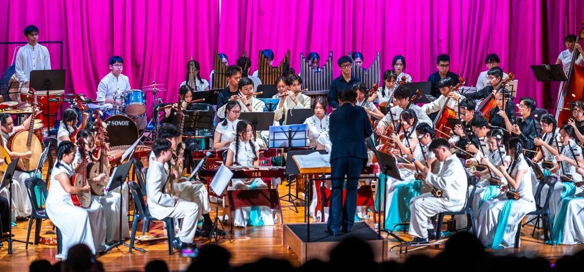 华乐团成员聚精会神，跟随指挥的动作投入演奏《邓丽君金曲联奏》。（南洋初级学院摄影学会提供）