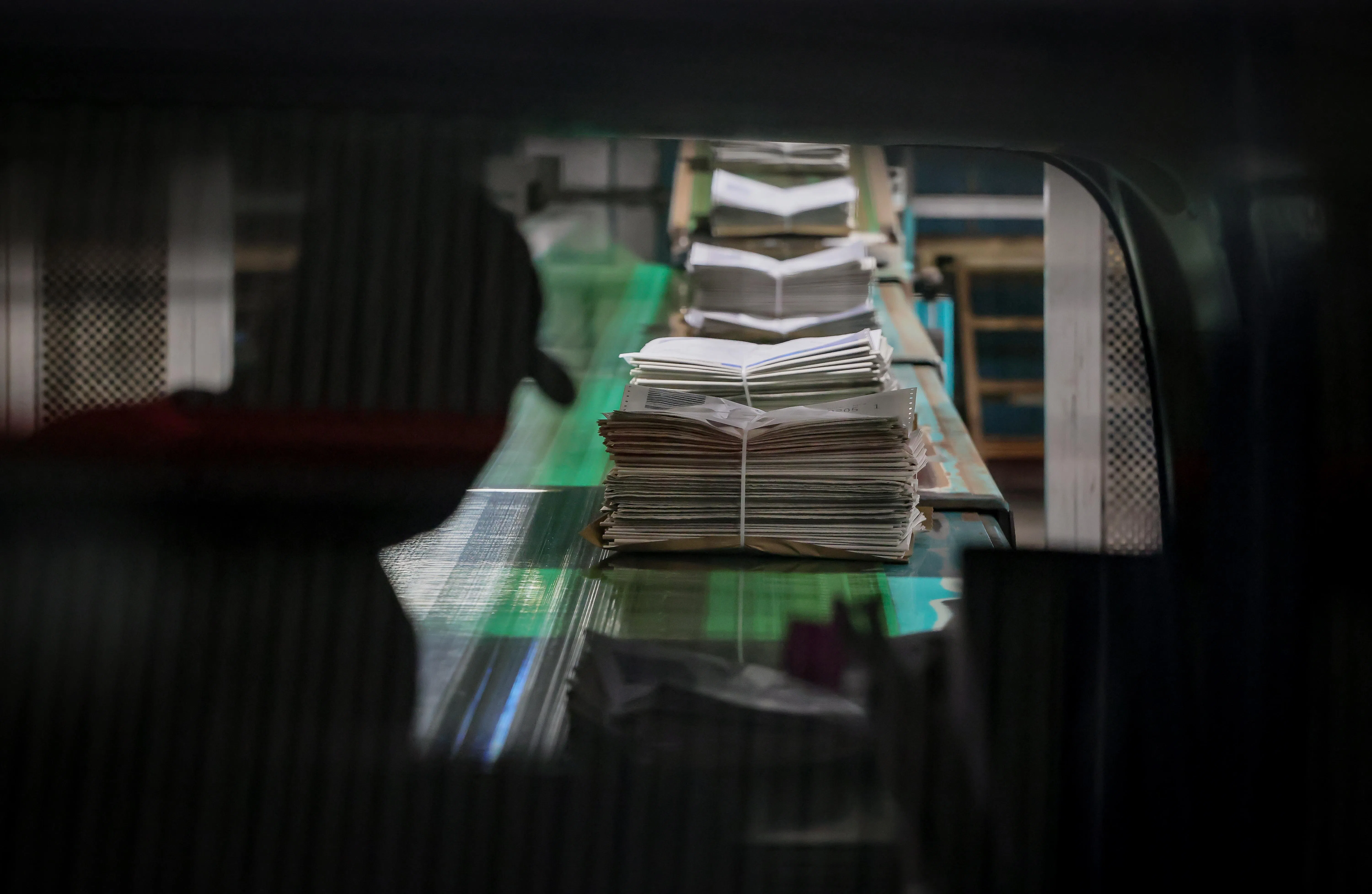 清晨的报纸泛着光，如一袋袋面包，默默履行着它作为“精神粮食”的职责。（龙国雄摄）