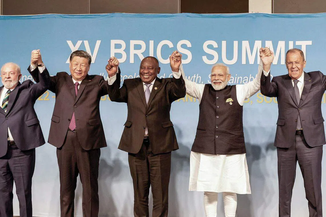 金砖国家领导人第十五次会议8月22日至24日在南非约翰内斯堡举行，图为峰会首日，巴西总统卢拉（左起）、中国国家主席习近平、南非总统拉马福萨、印度总理莫迪，以及代表俄罗斯总统普京与会的俄国外长拉夫罗夫一同举手合影留念。（法新社）