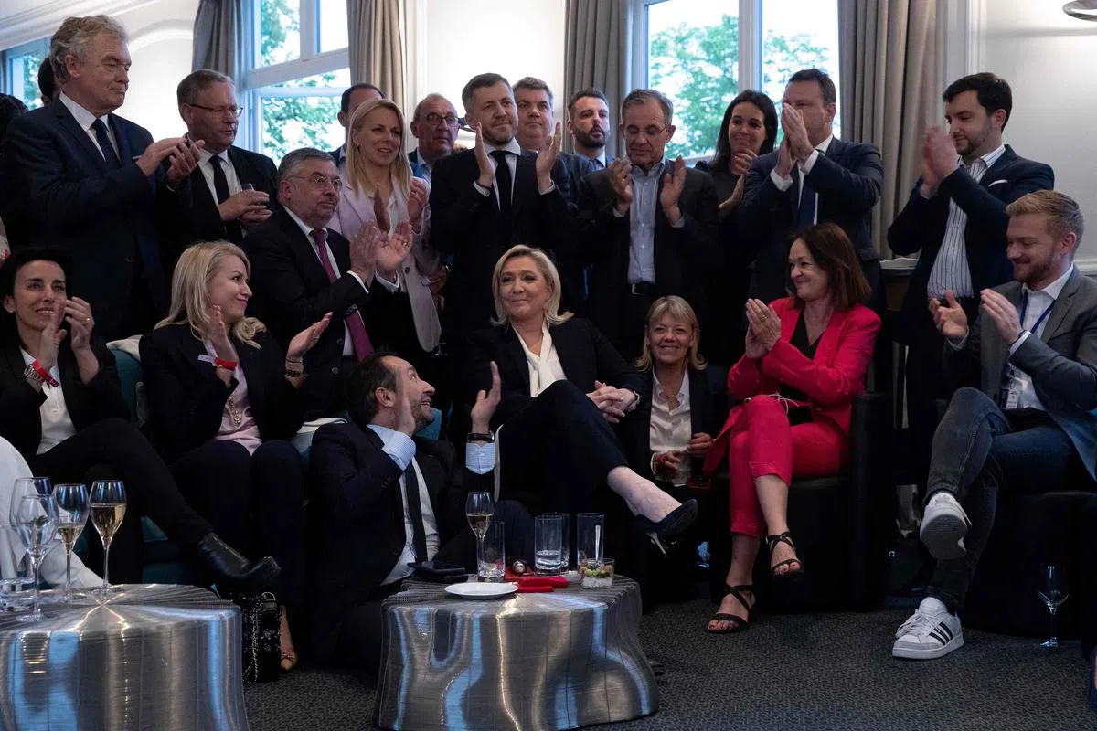 法国总统候选人勒庞（中）的支持者在第二轮总统选举的出口民调结果出炉后，以鼓掌表达对勒庞的支持。（法新社）