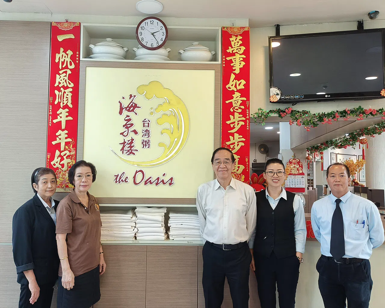 海京楼老板程文銮（右三）与餐馆部分老员工。（何智圆摄）