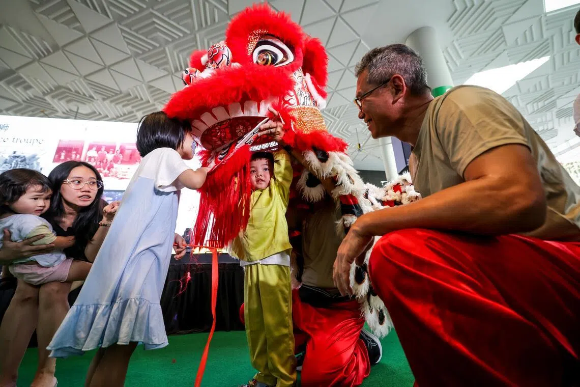养正小学校友会舞狮俱乐部的一些年长校友做舞狮示范，让孩童体验舞狮乐趣。（叶振忠摄）
