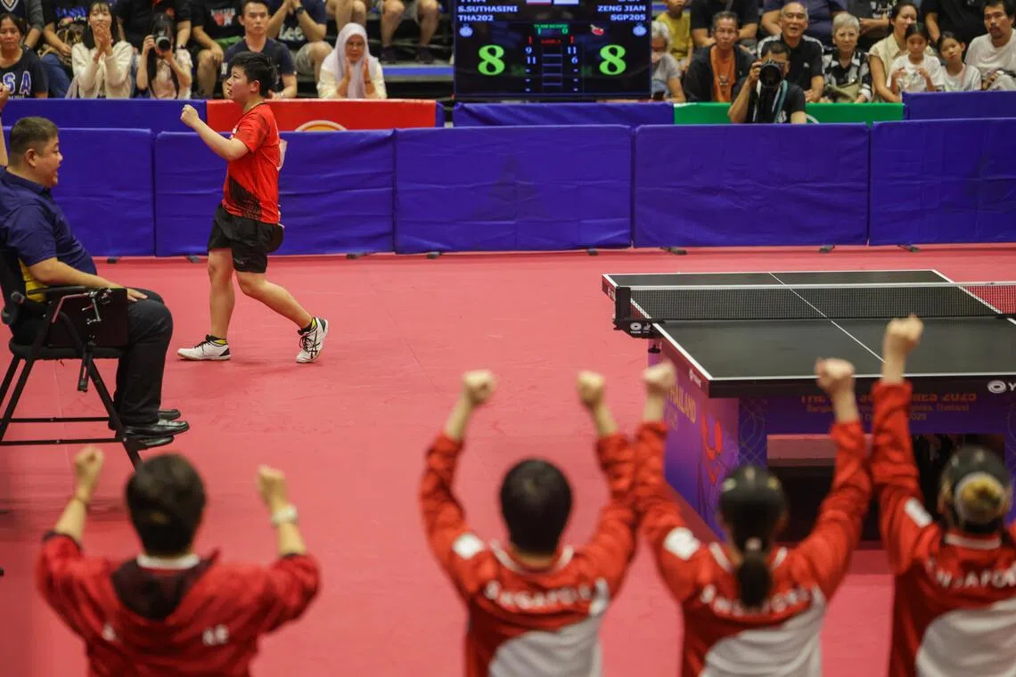 曾尖（上方红衣）在对垒素塔西尼得分时，队友和教练（下方）也都一起站起高举双手庆祝。（白艳琳摄）