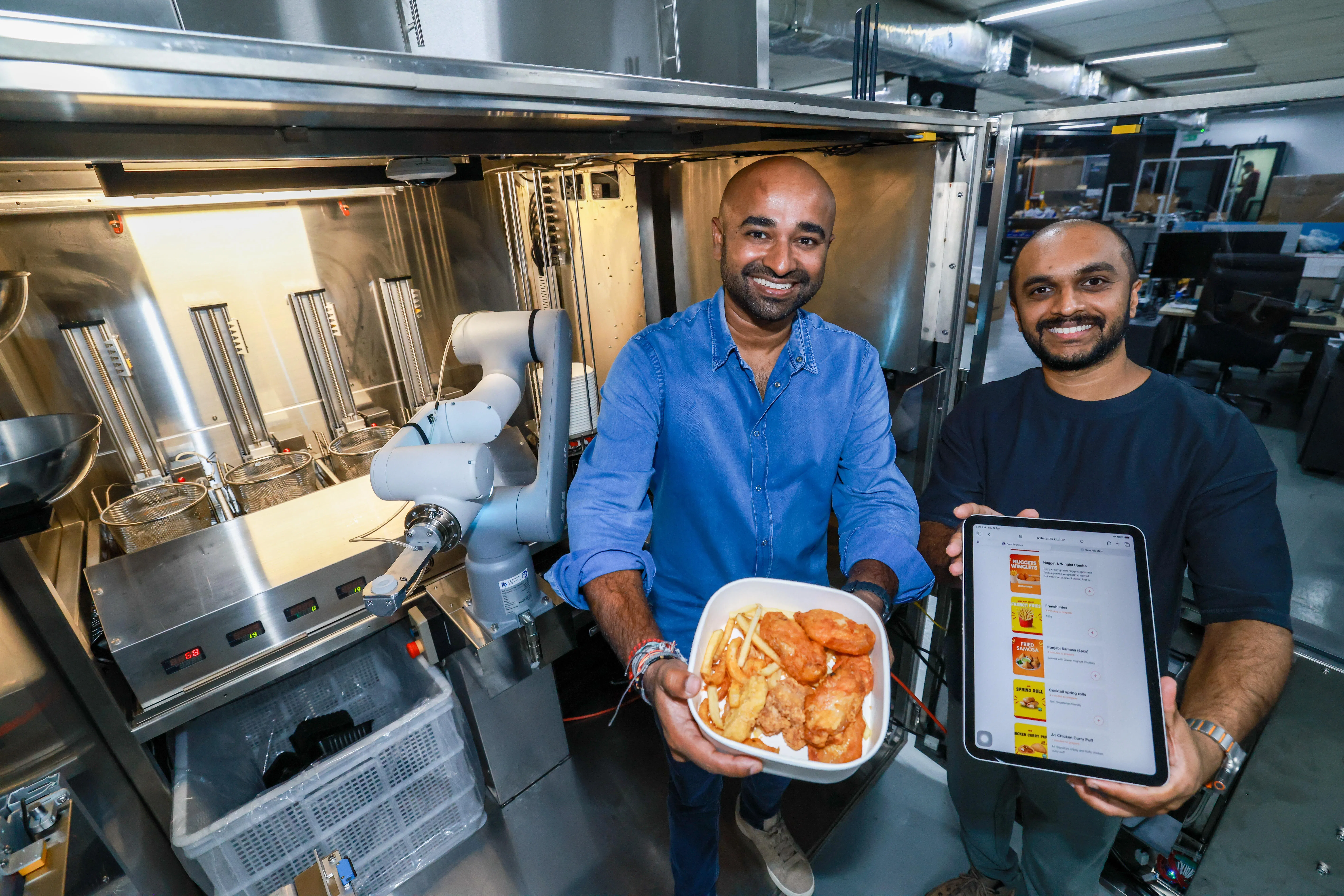 Rolo Robotics联合创办人兼总裁拉维（Ravi Nahappan，左）是餐饮经营者，他深知在本地聘请和培训员工的难处，因此同首席技术官兼联合创办人图沙尔（Tushar，33岁）合作开发微型厨房。（陈斌勤摄）
