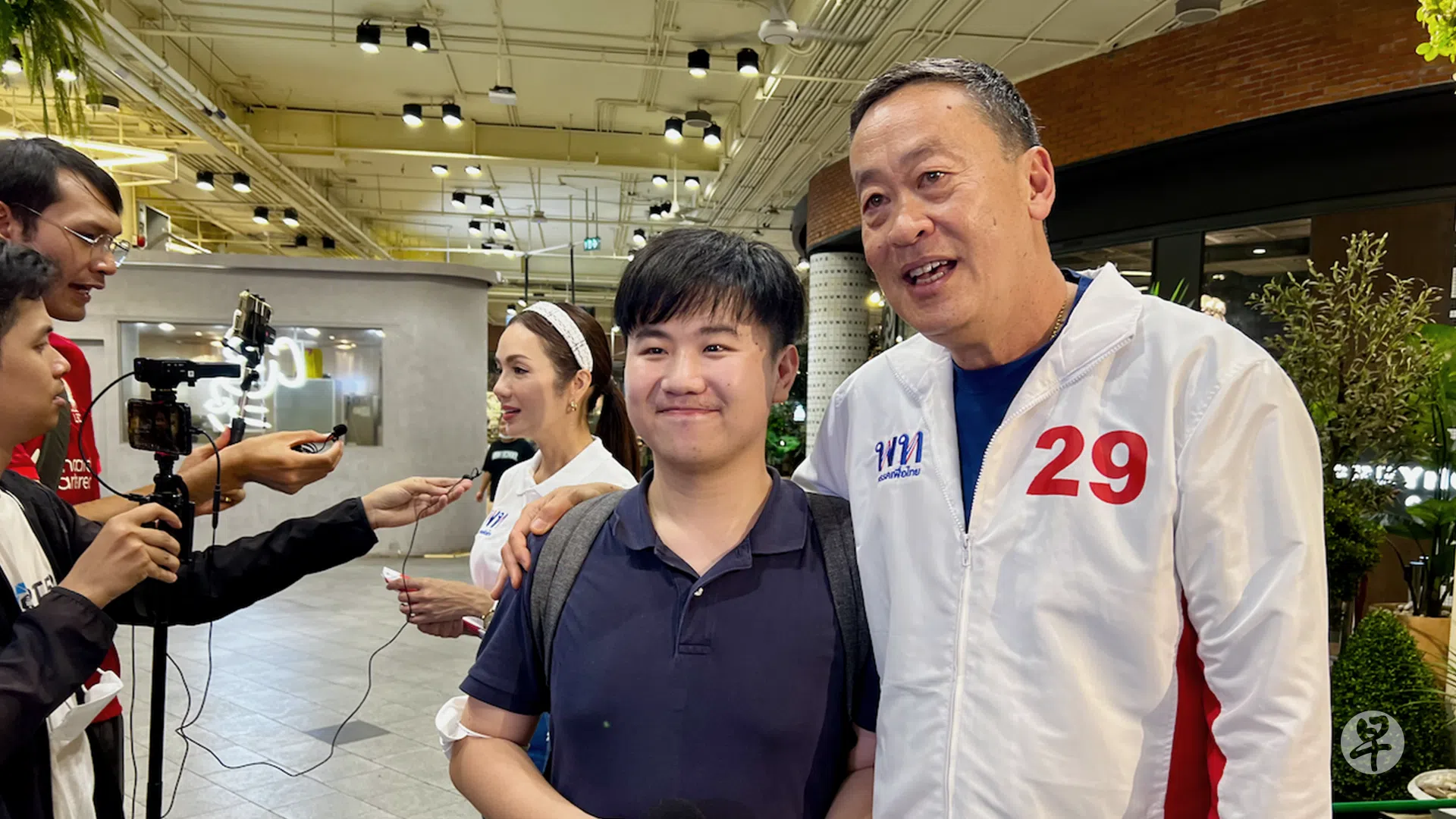 2023年5月泰国曼谷，入职未满一年的早报年轻编导邴泓剑直击为泰党候选人杜德他（右）竞选场子，有机会近距离采访这位为泰党顾问；当时大概没料到杜德他最终当选为泰国第30任首相。（吴汉钧摄）