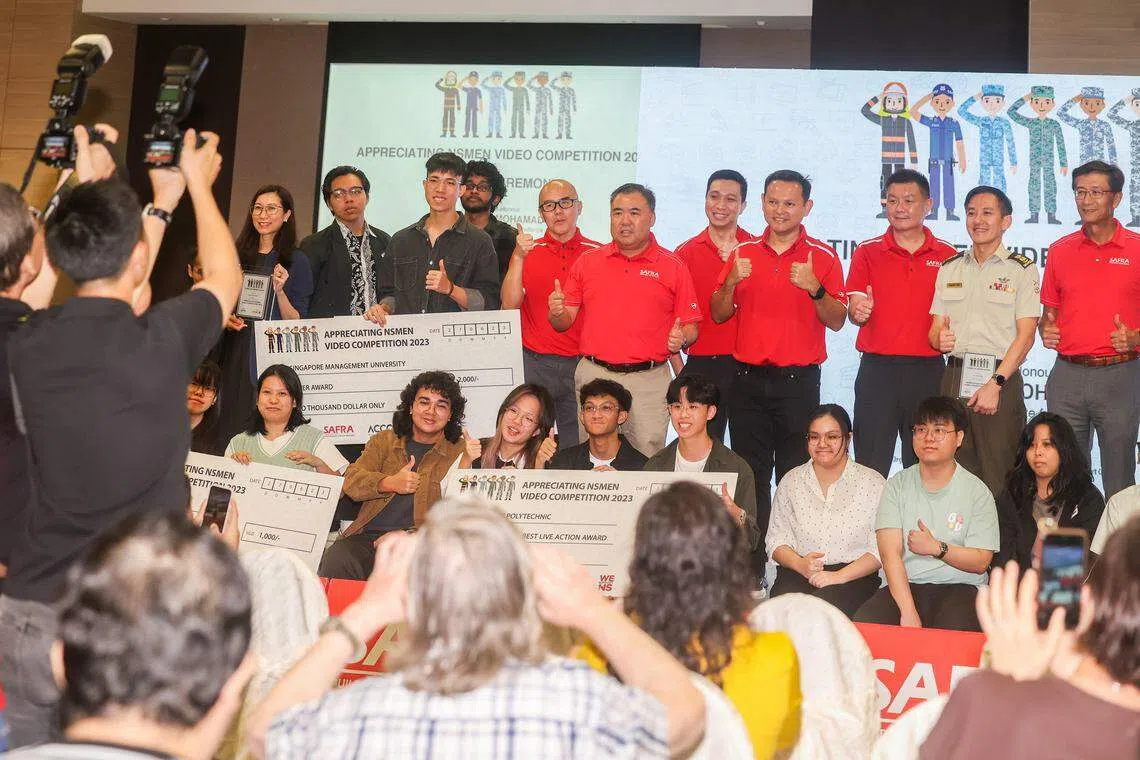 国防部兼人力部高级政务部长扎吉哈（后排右四）星期二在大巴窑战备军人协会俱乐部，为视频比赛的得奖者颁奖。今年参赛的视频共有71支，最终10部作品脱颖而出，获颁奖项。（陈斌勤摄）