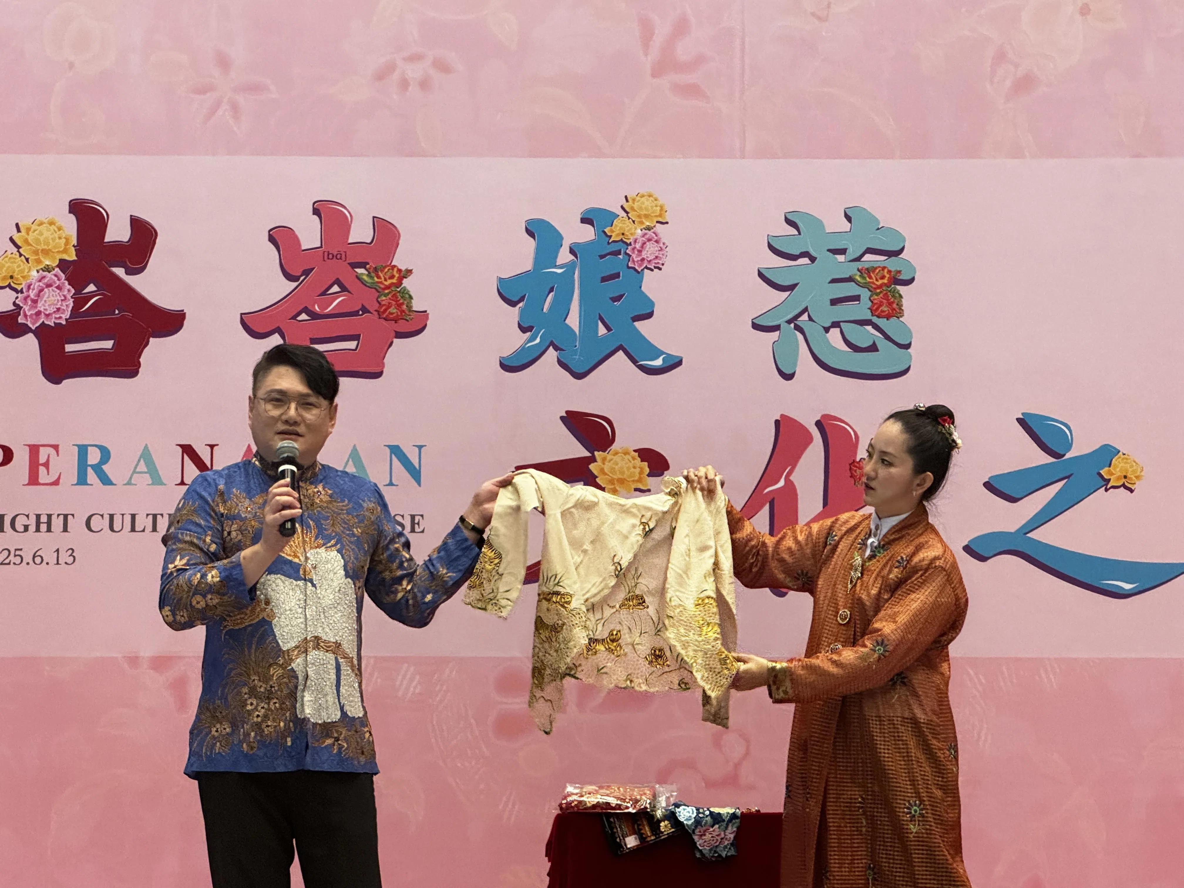 今年6月13日，新加坡娘惹服装设计师黄俊荣（左）在北京首都博物馆展示他收藏和设计的卡峇雅。（沈泽玮摄）