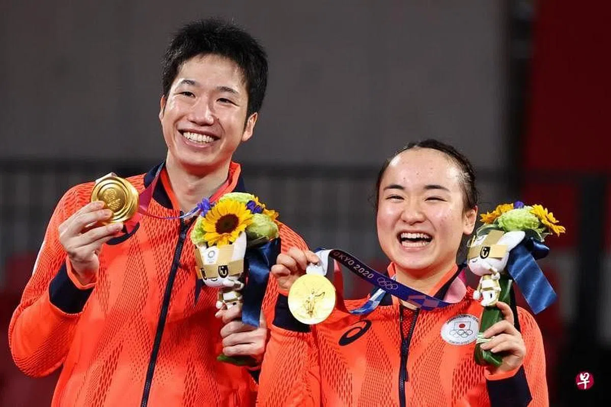 水谷隼（左）和伊藤美诚夺得历史性冠军后展示金牌。（路透社） 