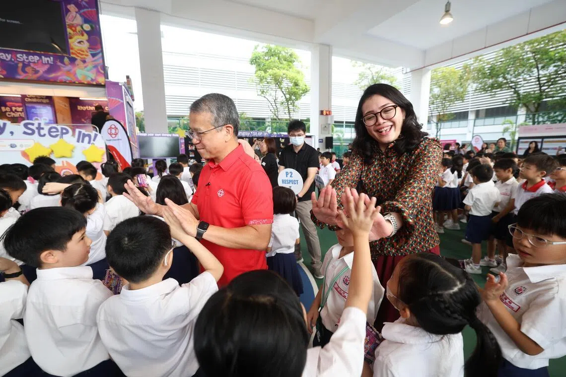 律政部长兼内政部第二部长唐振辉（左）和东海岸集选区凤山区基层组织顾问何礼娜（右）一同为活动揭幕，并与卍慈学校的学生互动交流。（关俊威摄）