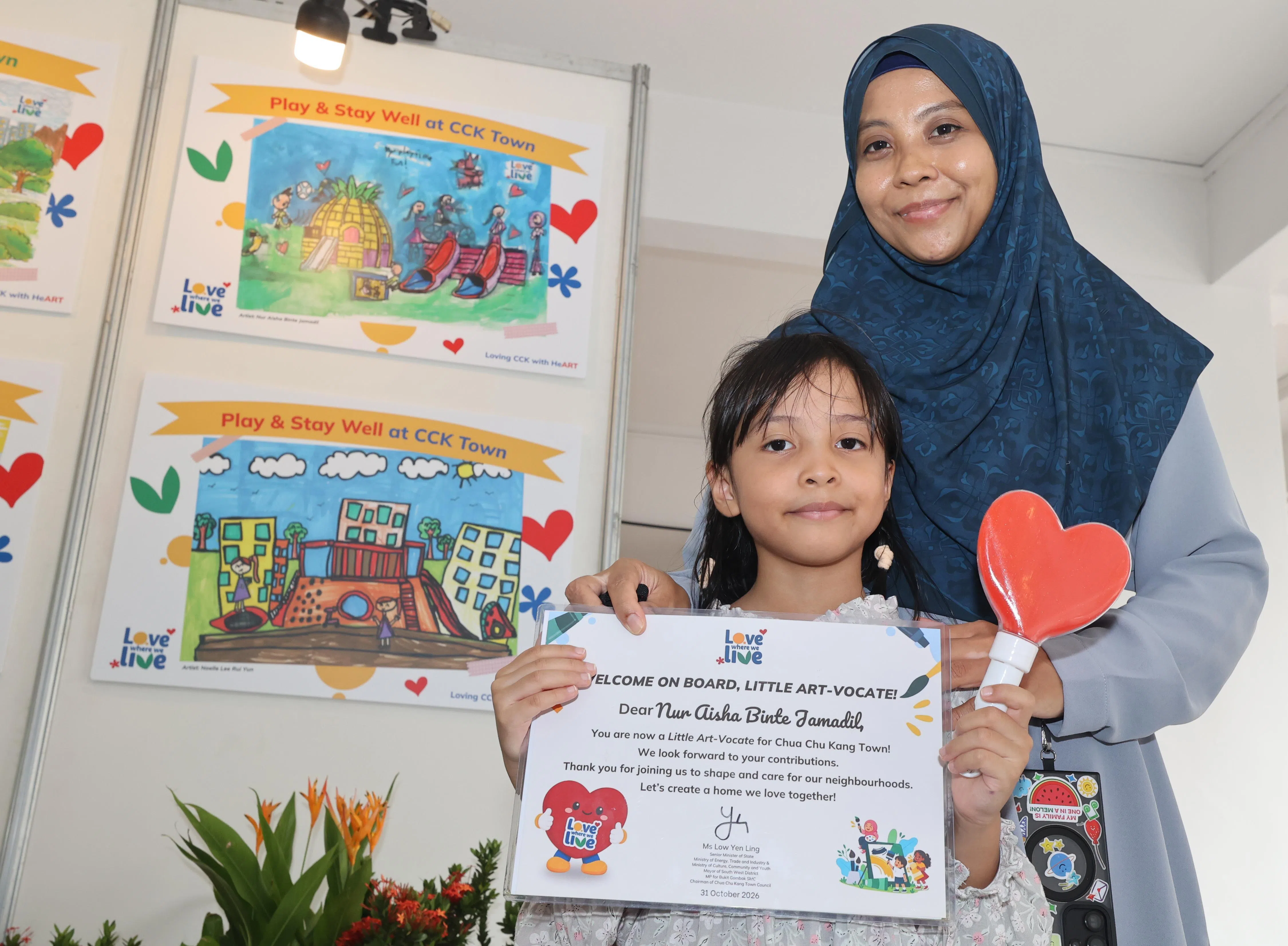 获得学前儿童组前六名的艾莎（Nur Aisha Binte Jamadil，6岁）选择画出位于登加、以凤梨为造型的游乐场。艾莎的母亲扎希拉（右）说，游乐场也是女儿在蔡厝港最喜欢的地方之一。（邬福梁摄）